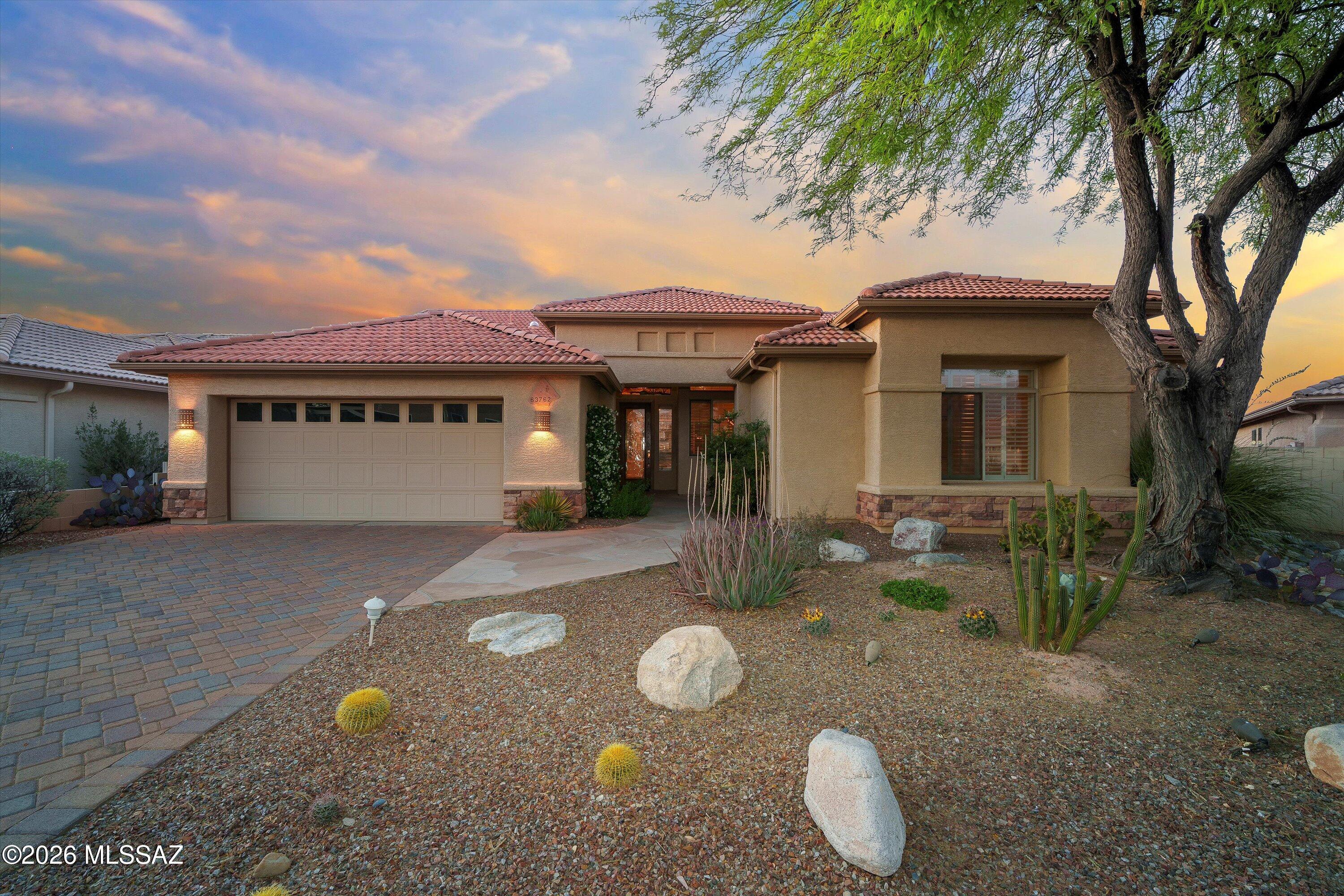 Tucked inside the highly sought-after SaddleBrooke community, this beautifully maintained home offers peaceful desert living with stunning mountain views from the backyard. The inviting curb appeal features mature desert landscaping, a paver driveway, and a welcoming covered entry. Inside, tall ceilings and abundant natural light create a spacious feel. The open living area includes large windows, plantation shutters, and custom built-in shelving. The kitchen offers generous cabinetry, ample counter space, a center island, and a built-in workspace. Step outside to enjoy the covered patio and overlooking a private desert backyard made for taking in Arizona's beautiful sunsets. Located in SaddleBrooke, known for its golf, pools, fitness centers, dining, and active living