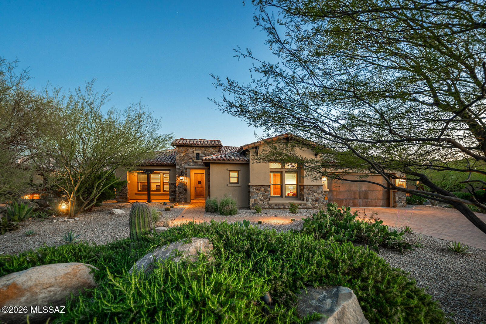 Open House Sunday 1 - 4 PM May 3rd | This well-built and maintained home affords comfortable living and easy access to the Stone Canyon Golf Club, consistently ranked in the top 100 in the country.  Inside, the great room's Mid-Century Modern design features a sliding wall of glass that fills the space with natural light and Catalina mountain views.  The living area includes a built-in electric fireplace. The kitchen includes a large curved island, separate dining area, walk-in pantry, and pocket office. The high-ceilinged  primary suite is spacious and also affords great views of the mountains.  The Primary Bath has dual vanity sinks, a separate vanity, soaking tub, walk-in shower, and a large walk-in closet. Two additional bedrooms each have en-suite full baths, and a bright, airy office includes its own fireplace. A standout feature of the home is the expansive 500 SF covered patio, designed as a true extension of the living space. Anchored by a stately fireplace and outdoor TV, the patio is ideal for indoor/outdoor living and entertaining. Remote-controlled screens fully enclose the space when desired, while large stacking sliding doors open wide to connect the interior with the outdoors, effectively creating an additional living area.  
The backyard features professionally designed landscaping with a fire pit, waterfall feature, built-in barbecue, and flagstone patio.  The home's exterior has recently been painted and is move-in ready. Located inside the main gate, it is a short distance from the golf  course, fitness center, pool, tennis, and pickle ball facilities. A private gate and cleared path from the home's backyard leads directly to the Vistoso Trails Nature Preserve, which provides a 6.2-mile paved trail through the Sonoran Desert with outstanding views of the Catalina and Tortolita Mountains, and opportunities for biking, hiking, and bird watching.
The property works well as either a full-time residence or an easy lock-and-leave home for part-time residents.
