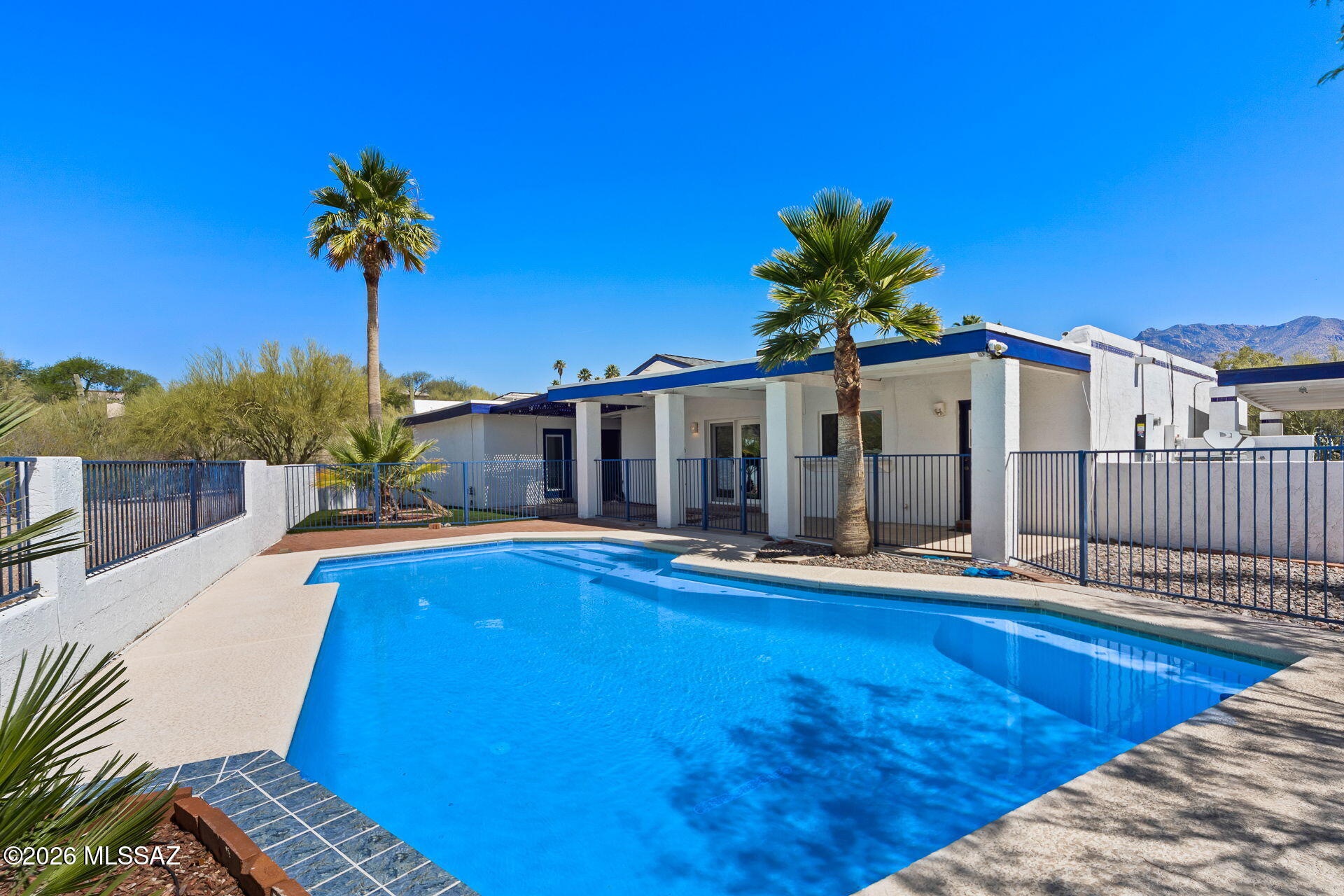 Tucked away on a private lot, 4581 N Avenida Del Cazador offers a highly accessible Catalina Foothills location paired with peace and quiet. Set far back from the road down a dedicated paver driveway, this classic single-story masonry stucco home is completely surrounded by desert open space. This single-story home features 2,234 square feet with no interior steps. 

Inside, you will notice fresh neutral paint, Saltillo tile in the main living areas, soaring ceilings, and a two-way stone fireplace provides a natural separation between the main living spaces.
Outside, the fully fenced backyard is low-care and ready to enjoy, featuring mature palm trees, artificial turf, and a newly plastered tailored for Tucson summers. The attached two-car garage, two additional carports and extra space around the property provides excellent coverage for vehicles.  Don't miss the generous space on the west side of the property offering excellent potential for expanding your outdoor living area or adding other improvements.

Many functional upgrades have recently been made to the home, including a new roof (2023), fresh interior paint, and new carpet in the bedrooms and hallway. Additional improvements include newer HVAC systems (2023/2015), all windows replaced since ownership, new pool tile and plaster (2026), driveway and carport enhancements, and a new Tesla solar system to maximize sustainability (2024).

This location offers incredible convenience to enjoy everything that Tucson has to offer. Access to "The Loop," a 135-mile paved multi-use path is only a mile walk or ride but also includes a parking area. Within a mile there are robust school options, including BASIS North, The Gregory School and Castehill Country Day School. Within that same 1-mile radius you will enjoy access to Whole Foods, Natural Grocers, a pharmacy, bank, fitness facilities and various retail shops. TMC is 8 minutes, Sabino Canyon is 9 minutes, and the University of Arizona is under 20 minutes.