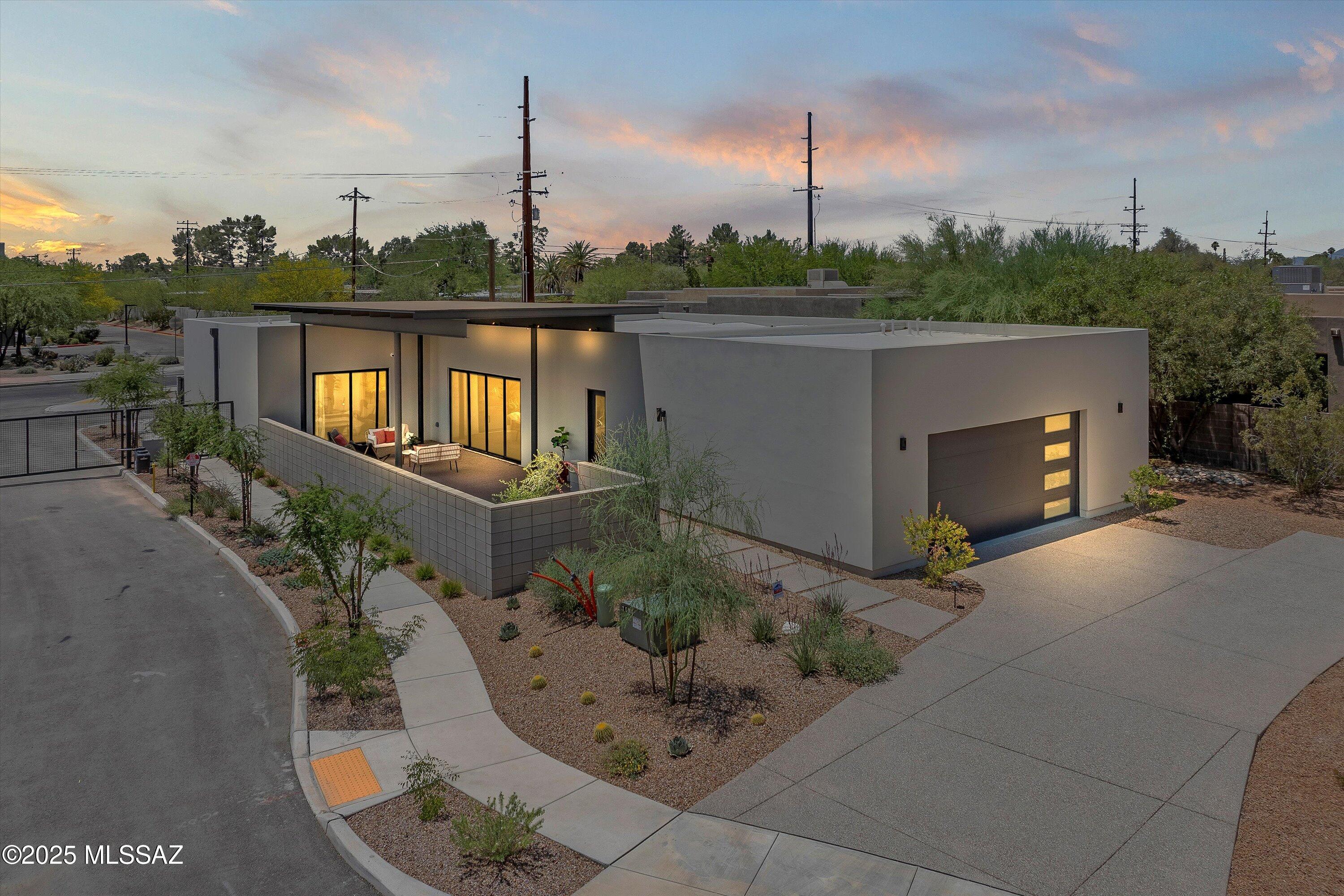 NEW CONSTRUCTION!
Welcome to Terraza Moderna, a gated enclave of only six architecturally distinct homes nestled minutes from Tucson's iconic Old Fort Lowell Historic District.
This is the premier residence completed in the exclusive collection, thoughtfully crafted by the award-winning team at Rob Paulus Architects and built by The Helios Group. Known for his modern, contextually grounded designs, Paulus brings his signature blend of clean lines, natural materials, and indoor-outdoor harmony to life in this one of a kind home. Perfectly positioned in close proximity to Tucson Medical Center and just minutes from The Loop (America's longest urban biking path)Basis Tucson North(one of the top rated schools in Arizona), the Catalina Mountains, hiking trails, golf courses, downtowTucson, and some of the city's most celebrated restaurants and shopping, this home is ideally located.
Step inside to a refined yet grounded living space filled with natural light, soaring ceilings, and polished concrete floors that provide both warmth and continuity. The open floor plan is designed for easy living and flows effortlessly to a private courtyard style canopy framed by expansive double sliding glass doors, blurring the boundaries between interior and exterior living. Designed for tranquility and connection, an intimate open-air alcove between the two bedrooms offers a peaceful setting for morning coffee or meditation.
At the heart of the home is the kitchen, glistening in subtle luxury and function, featuring an exceptional 14-foot Caesarstone quartz island with a creamy concrete finish, under-cabinet lighting illuminate and showcase the soft close, walnut cabinetry, while an integrated wine fridge, Bosch appliances and natural wood finishes reflect a modern yet comfortable aesthetic, ideal for both everyday living and entertaining on a grand scale.
Each bedroom includes its own en suite bath, while the primary suite offers breathtaking Catalina Mountain views, a luxurious soaking tub, spa-like finishes, and a private sliding door that opens to the outdoor living area. The tiled shower walls soar to the ceiling in every bathroom, lending a sense of height and elegance, and a spacious powder room is thoughtfully placed for guests. The home also offers a dedicated laundry room with a sink and added storage, as well as an oversized two-car garage with generous space for gear or tools.
Every inch of this home has been intentionally designed with form, function, and serenity in mind, yet still leaves room for you to add your own touches and make it your personal desert sanctuary.
Polished, peaceful, and architecturally remarkable, this home is a rare offering in one of Tucson's most treasured and connected locations.
using Apple Maps? Use this address to find us- 5001 E. Glenn St.