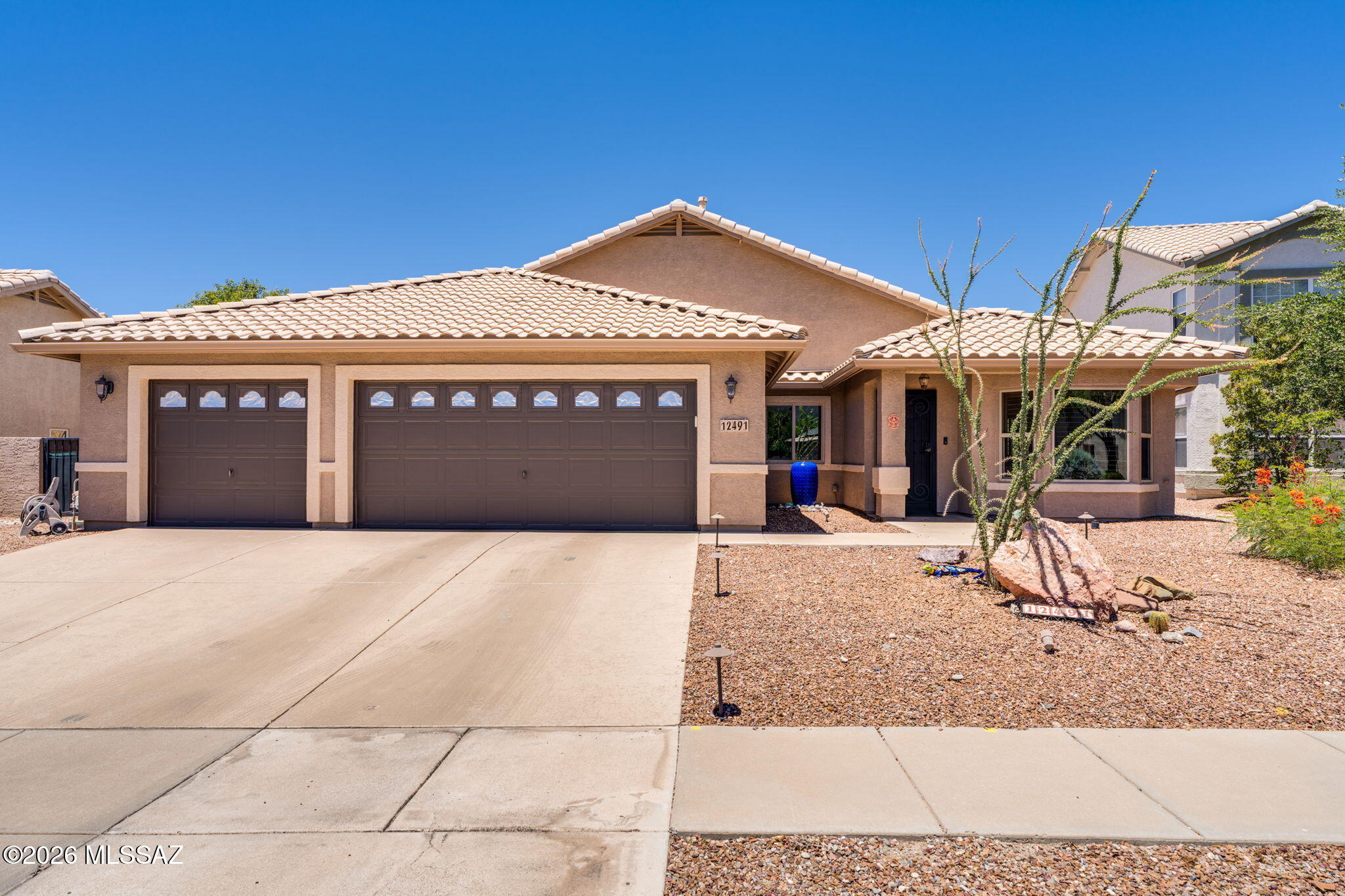 Discover the epitome of relaxed, single-story comfort tucked away the heart of Oro Valley. Offering a beautifully maintained 3BD/2BA+Den/Office (1,928 sqft footprint), this contemporary residence masterfully maximizes space and natural light, crafting a warm, inviting ambiance that perfectly supports both peaceful daily unwinding and seamless hosting. At the heart of the residence is a bright, open great room and culinary hub positioned right off the kitchen. The kitchen itself boasts durable stainless-steel finishes, a casual breakfast bar for morning coffee, with a beautiful porcelain center island. The sweeping primary suite provides a serene sanctuary complete with dual master sinks and a massive shower layout. Two additional well-sized bedrooms offer ample space and privacy. The indoor spaces ease out beautifully to an east/west-exposed lot framed by low-care desert plantings and mature landscaping. The private rear yard is entirely wrapped in a sturdy block-wall fence, offering a secure environment to enjoy magnificent morning sunrises or host twilight dinner gatherings on the wide covered patio. Complete with an attached 3-car garage (a rare and highly coveted asset in the community) you will find an abundance of deep storage space for hobbies, tools, or your personal golf cart. Balanced with close proximity to fine dining, medical care at the Oro Valley Hospital, and retail options along Rancho Vistoso Boulevard, this residence delivers a premier desert lifestyle.