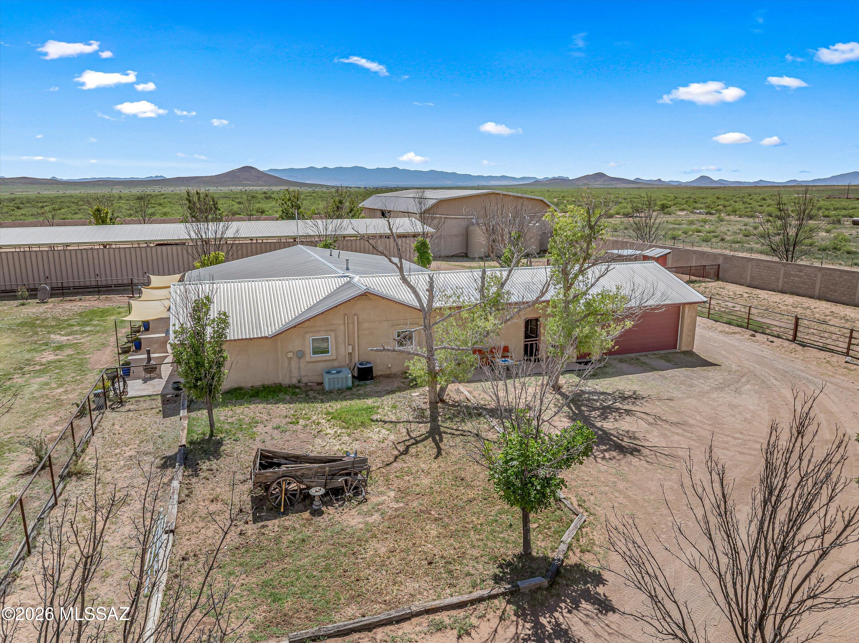 Welcome to Antelope Rd - The Yaqui Hideout, an exceptional 30-acre working ranch retreat where wide-open skies, breathtaking mountain vistas, and unforgettable Arizona sunsets create the ultimate backdrop for authentic country living. Nestled in the heart of Arizona's high desert and just off the renowned Willcox Wine Trail, this extraordinary property offers not only privacy and ranch functionality but also access to some of Southern Arizona's most celebrated outdoor recreation, world-class bird watching, and endless adventure. Set on 30 private acres, 4 of them tucked behind a 10-foot block wall and secure gated entrance, this remarkable estate offers the rare opportunity to embrace the ranch lifestyle with privacy, infrastructure, and space to truly make it your own. Imagine ending each day on the porch, watching the sun dip behind the nearby mountains as the sky transforms into brilliant shades of gold, crimson, and violet, while your livestock settle in for the evening and the peaceful rhythm of ranch life takes over. Designed for both comfortable living and agricultural functionality, the home is perfectly suited for raising livestock, equestrian pursuits, homesteading, or operating a destination ranch retreat. Currently operating as a successful bed & breakfast, it offers incredible flexibility as an income-producing property, private family compound, or legacy ranch estate. The main residence features 4 bedrooms, 3 bathrooms, and a kitchenette, while the separate bunk house offers 5 additional bedrooms and 4 bathrooms (5th option), creating abundant accommodations for guests, ranch hands, retreats, or multi-generational living. A versatile fifth bedroom currently serves as a basket weaving studio, offering flexible space for creative pursuits, office use, or additional guest quarters. Built with the rancher in mind, the property is exceptionally well-equipped with a 6,120 sq. ft. barn, three 5,000-gallon water harvesting tanks, a private 500-foot well, pump house, owned propane tank, RV garage, equipment shed, greenhouse, and chicken coop. Livestock operations are fully supported with 8 pens inside the walled compound, an outdoor riding arena with 12 additional livestock pens, and 7 established pastures plus a fragrant lavender field, offering 8 total grazing and agricultural areas across the property. Perfectly positioned near the stunning Chiricahua National Monument, the property places you minutes from exceptional hiking trails, dramatic rock formations, scenic canyons, and some of the finest birding destinations in the country. Outdoor enthusiasts will appreciate easy access to hiking, horseback riding, wildlife viewing, stargazing, and exploring the rugged beauty of both the Dragoon and Chiricahua mountain ranges. Wine lovers will enjoy nearby tastings and vineyard experiences along the Willcox Wine Trail, making this location an ideal blend of rural tranquility and destination appeal. Whether your dream is raising livestock, riding beneath endless desert skies, cultivating the land, creating a vineyard, commercial opportunities welcoming guests seeking adventure and serenity, or simply savoring spectacular sunsets from your own private ranch sanctuary; a rare chance to own a true piece of Arizona's rural beauty, where every sunset reminds you that you're exactly where you belong.