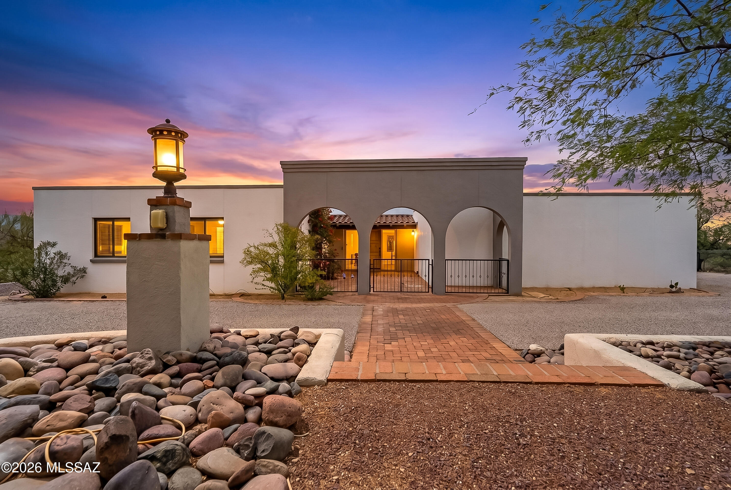 This beautifully updated ranch-style home blends timeless design with warm modern finishes and breathtaking mountain views from both the front and back yards. Inside, elegant travertine tile flooring flows throughout the main living spaces, creating a seamless and sophisticated feel. The remodeled kitchen and bathrooms feature sleek Danish wood cabinetry, combining clean lines with rich natural texture for a refined contemporary look. Additional built-in shelving adds both character and functionality, offering stylish storage and display space accompanying the gas fireplace. Large windows invite in natural light and frame the surrounding mountain scenery,  with exceptional indoor-outdoor appeal. This home sits at the base of the Catalinas with access to Mt Lemmon just 5 minutes away.