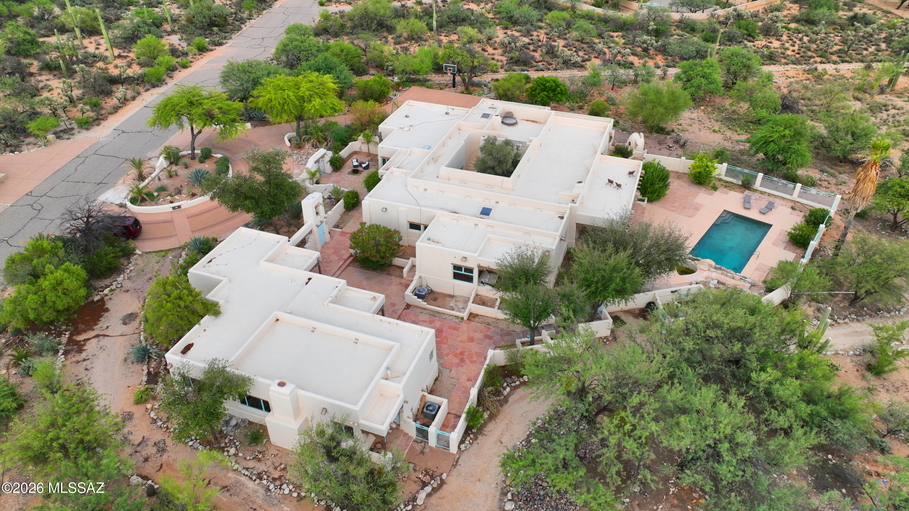 Experience the pinnacle of Southwest luxury with this extraordinary Santa Fe-style estate nestled on 6.53 private acres at the base of the majestic Catalina Mountains in the heart of the Tanque Verde Valley. Designed with exceptional craftsmanship and timeless architectural detail, this one-of-a-kind horse property offers approximately 4800 square feet in the main residence with 4 bedrooms and 4.5 bathrooms, plus a beautifully appointed 1,600+ square-foot guest casita featuring 2 bedrooms, 2 bathrooms, and a private sauna. From the moment you arrive, the home's striking architectural presence, artisan finishes, Copper ceilings, and top-quality materials set it apart. Flagstone flooring flows throughout the main home, while the gourmet kitchen features granite countertops, custom cabinetry, and opens to a formal dining room designed for elegant entertaining. Expansive picture windows frame the breathtaking surroundings, filling the home with natural light. A stunning central courtyard, covered patios, sparkling pool, and roof top patio make for the perfect indoor-outdoor lifestyle.
Equestrians will appreciate the exceptional facilities, including a custom Santa Fe-style 5-stall barn with tack room and hay storage, fenced arena, round pen, private well, and acres of usable land. Ride directly from your property with immediate access to the Agua Caliente Wash, Tanque Verde Wash, and miles of scenic trails extending east toward the Rincon Mountains--allowing endless horseback adventures without ever loading a trailer.
Surrounded by mature desert vegetation, towering saguaros, palm trees and panoramic mountain vistas, this remarkable estate offers unmatched privacy while remaining just minutes from Tucson's conveniences. A rare opportunity to own one of Southern Arizona's finest luxury equestrian properties, where authentic Santa Fe architecture, world-class horse amenities, and spectacular desert beauty come together in perfect harmony.
