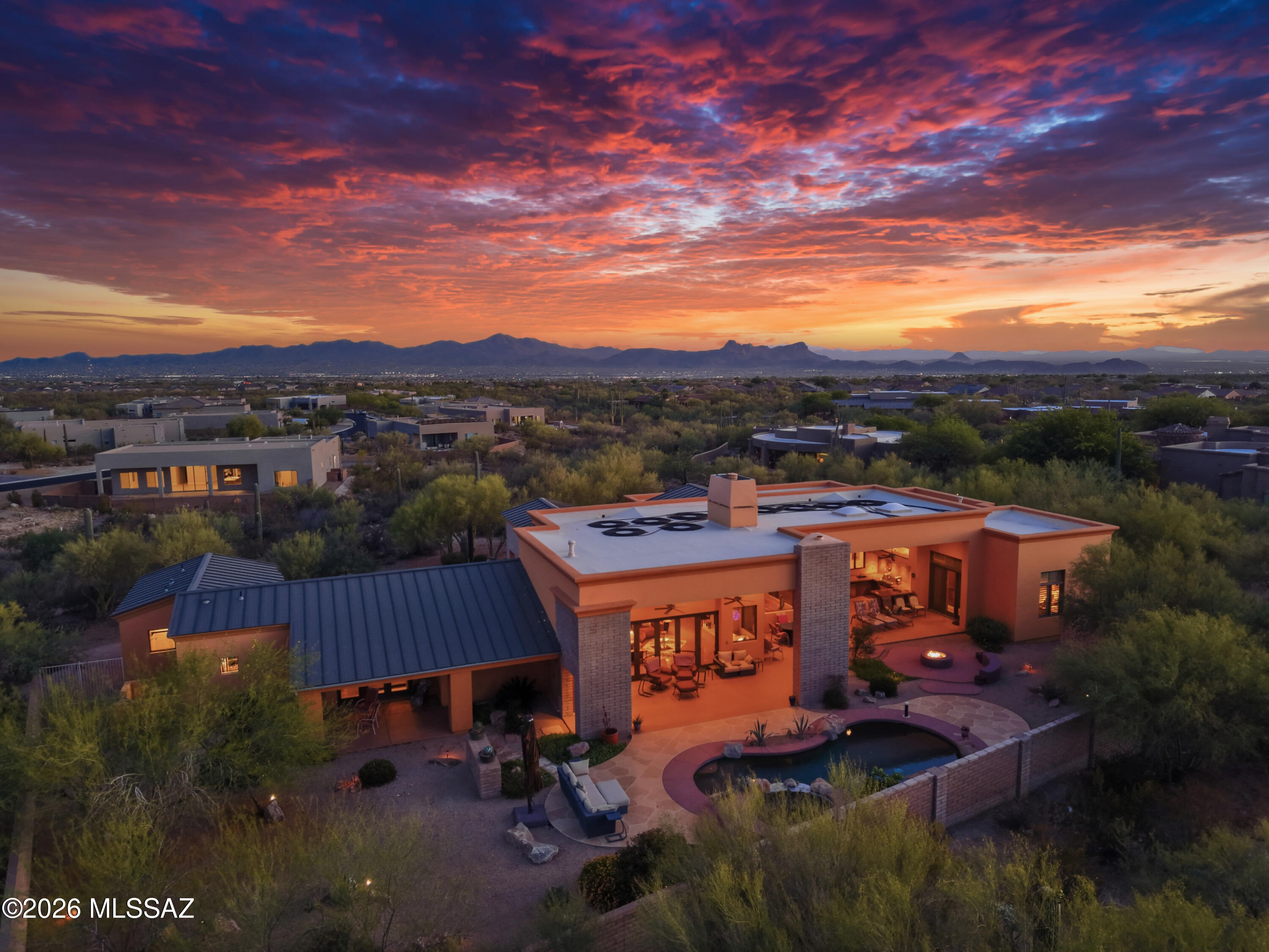 Behind the gates of an intimate enclave of just seven custom luxury homes, surrounded by mature Palo Verde trees and iconic Saguaros, sits a modern desert sanctuary where elegance, architecture, and nature live in Harmony. The over 4,000 sq. ft. custom residence offers the rare balance of privacy and close proximity to everyday conveniences_ groceries, dining, medical care, and services are only minutes away. From the moment you step through the 10-foot steel-and-glass entry, the home opens to dramatic volume and light. 18-foot ceilings and floor-to-ceiling glass draw the outdoors inward, while an 18-foot wall of folding doors transforms the great room into a seamless indoor-outdoor living experience. .  Morning light, desert breezes, and evening sunsets become part of the daily life. The gourmet kitchen impresses with professional Thermador appliances- dual microwaves, dual dishwashers, a warming drawer, five-burner gas cooktop, large refrigerator/freezer- all surrounded by rich custom cabinetry and expansive granite surfaces. Whether hosting dinners or lively gatherings, the space flows effortlessly into the great room, dining areas, and media/theater room. Throughout the home, attention to detail elevates every moment: Kohler fixtures, custom cabinetry in a warm wood tone, and whole-home audio with 18 speaker and multi-zone controls. Approximately 170 integral lights, plus landscape lighting, create ambiance day and night. The master suite offer the luxury of space and serenity, featuring a spa-inspired bath with eight-head electronically controlled walk-in shower, Jacuzzi tub and a generous walk-in closet. Guest rooms each include walk-in closets as well.
Outdoors, a resort-quality pebble pool and spa are joined by a cascading waterfall, enhanced by a secondary motor for dramatic effect. Solar heating extends the swim season from spring through fall, and the entire pool system can be controlled manually or from a smartphone- luxury with ease. A Remarkable Value: This home was originally built at a cost of just under $1.4M, and the cost to replicate it today would be $2.5-$2.7M. Yet it is offered at $1,750,000- significantly below construction value and an exceptional opportunity to own a luxury custom home at a price rarely seen in the current market. A Place For Celebration or Sanctuary: Here evenings glow with soft landscaping lighting and cascading water. The home easily becomes a gathering space for friend and family- or a private retreat for reflection and renewal.