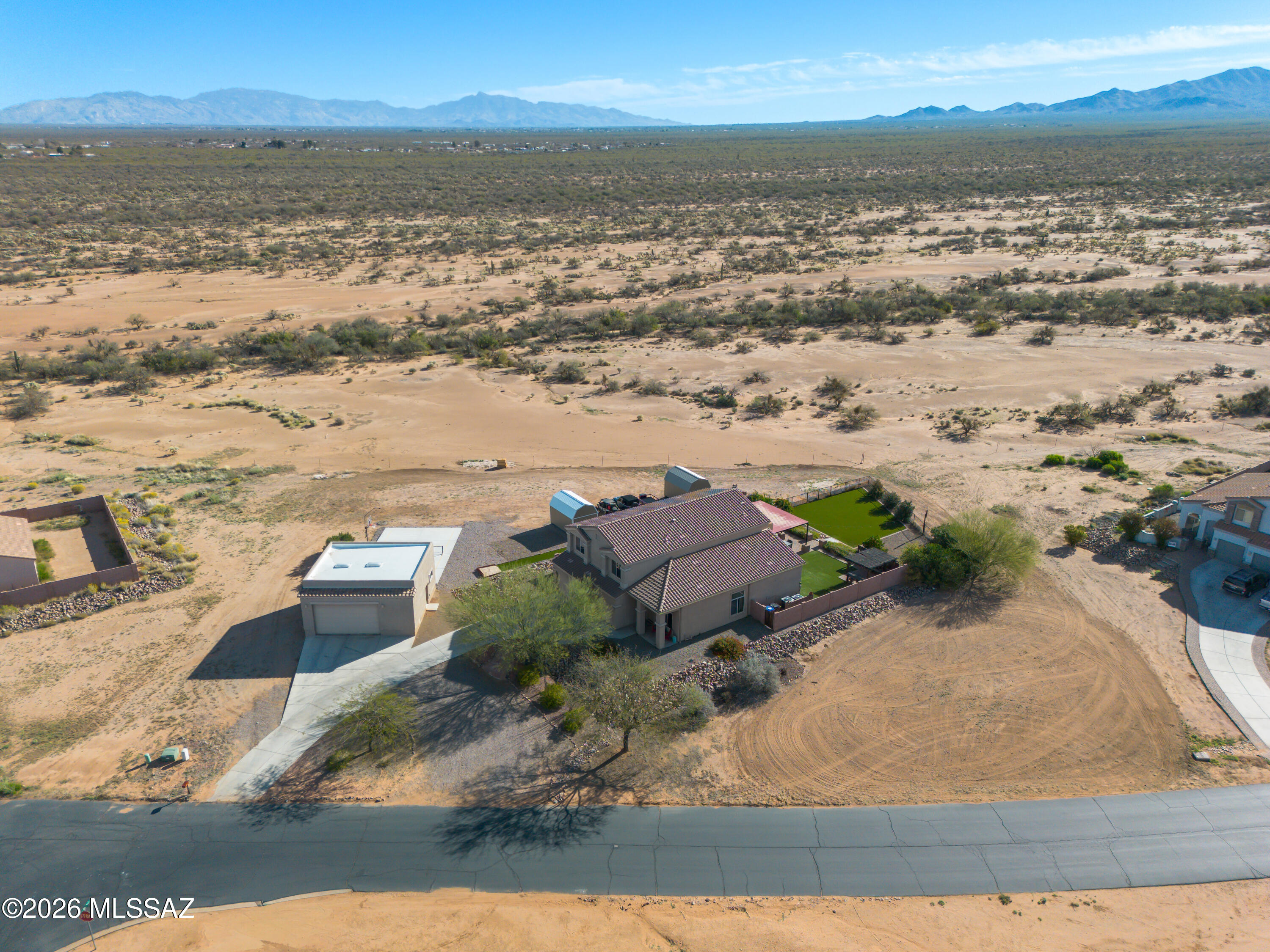 Located in Sahuarita Highlands, a unique fully developed neighborhood known for oversized lots, privacy, and sweeping mountain views, this impressive 3,185 sq. ft. home offers space and versatility. Featuring 5 bedrooms and 3 full bathrooms, the property includes a 3-car attached garage plus an incredible 900 sq. ft. detached garage that is  heated and cooled--perfect for hobbies, a workshop, or extra storage. Enjoy Arizona living in the backyard with a 22' x 22' covered patio, quality turf, and panoramic mountain views, ideal for relaxing or entertaining. Inside, soaring two-story ceilings create a bright, open feel. The front living and dining area offers flexible space for a second living room, play area, or office. The kitchen features dark wood cabinetry, granite countertops, an electric range, and a spacious island, with beautiful mountain views from the window. It opens to the great room, keeping the cook connected to the action. The main floor also includes a large 
bedroom, full bath, and laundry room, ideal for guests or multi-generational living.Upstairs offers four additional bedrooms, including a primary suite with double doors and a private balcony overlooking the mountains. Additional highlights include two 
storage sheds and RV parking, making this home perfect for storage, hobbies, and outdoor living.