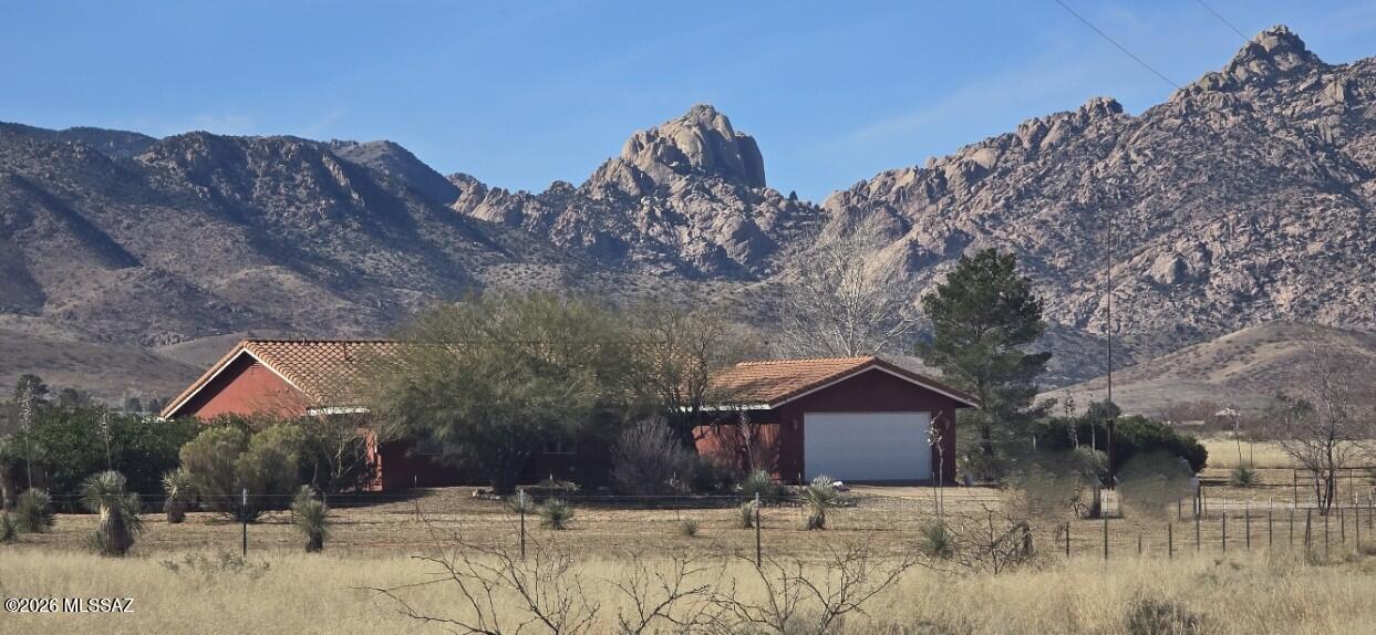 Country living on 5 fenced acres. This  Custom 2006 Territorial Home was designed to frame one of the best Cochise Stronghold views in the valley, with a large covered patio for your outdoor comfort. This 3 bdrm, 2 bath home features tile floors thru‑out, a kitchen w/ cherry cabinets & granite counters, with dining area off the kitchen flowing effortlessly into the large Great Rm. The primary suite includes a lg master bath w/ jetted tub, walk‑in shower, dbl vanity & lg walk‑in closet, plus a private door to the covered patio. Energy‑efficient living on the grid w/ minimal utility costs with private well, supported by solar system & backup propane generator (owned). Fruit trees, raised gardens, chicken coop & fenced dog run complete this peaceful setting.