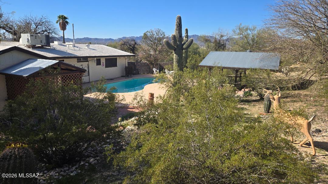 WOW, Breath taking views Make this your 3 bedroom 2 bath home with desirable features such as a swimming pool with a huge deck all around pool and ramada 16 x 16 on .36 acre all to enjoy those wonderful summer days. Or during the cool winter warm up with a fire place in the family room. Surrounded by Casas Adobes Neighborhood Park, which allows this home to only have one neighbor on the east side. Room for your RV, boat or your toys. Has a huge backyard with a pool and large deck for your patio furniture., enjoy the Tucson beautiful sunsets while relaxing on the top area. Backyard has a ramada 16 x 16 with electric to enjoy while taking a break from swimming and listening to your music . Covered slab area for a spa or put your BBQ on.  Ceramic tile flooring and vinyl, throughout home