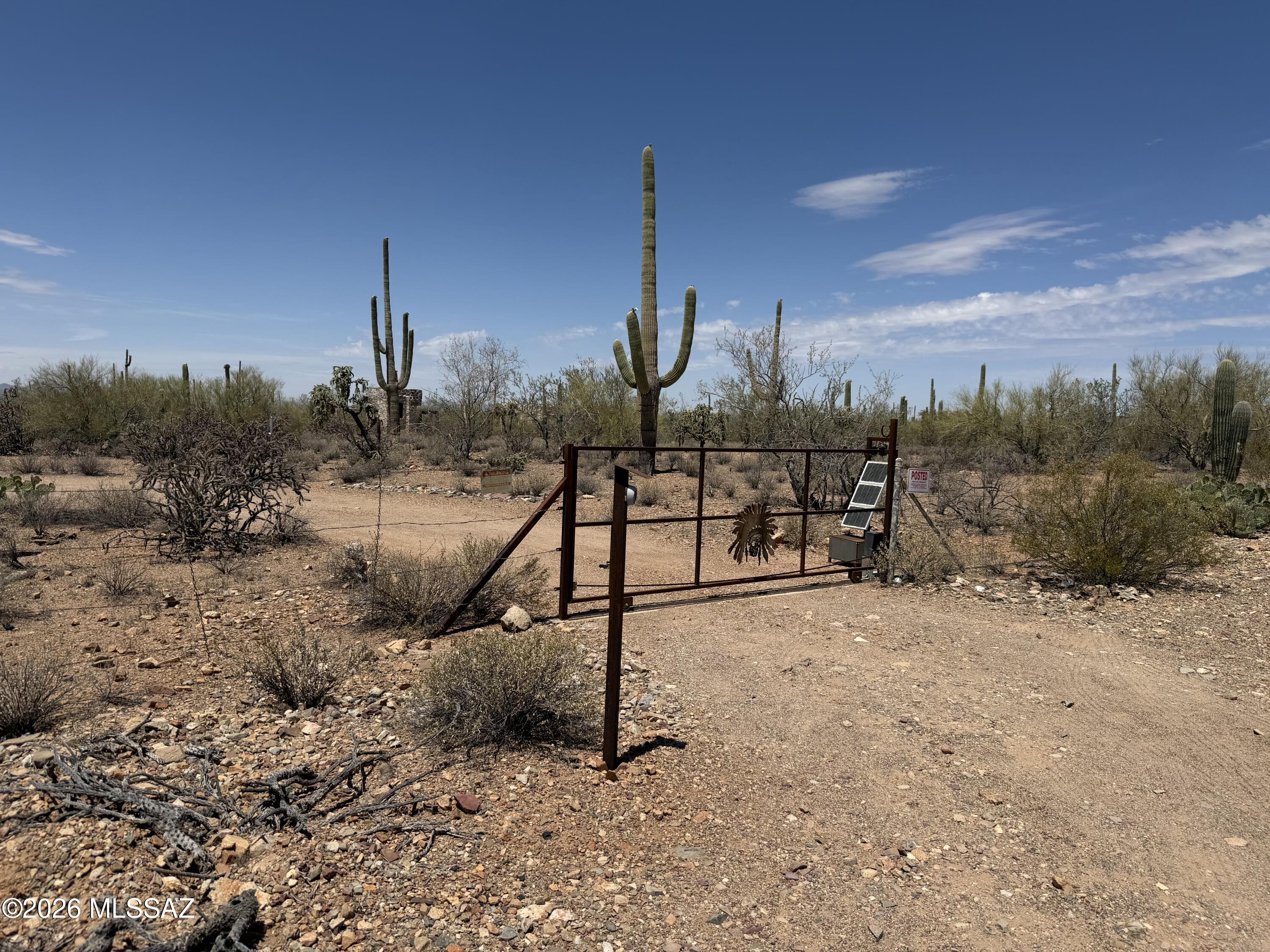 This 4.2 acres of the peaceful property offers the kind of quiet desert setting that's getting harder to find. Surrounded by mature saguaro cacti and wide-open mountain views, the land captures the natural beauty of the Sonoran Desert while still providing practical advantages-electric & water are available, no HOA. Tucked off the main road for added privacy, the property is accessed by a dirt road and secured by a private, solar-powered gate. A small cleared area & a unique Temple structure in place create an inviting space for gathering. For those ready to build or plan ahead, the groundwork has been started: survey, perc test, & previous site/build drawings are available. Whether you're looking for a private retreat or future homesite this property offers flexibility, character & value.