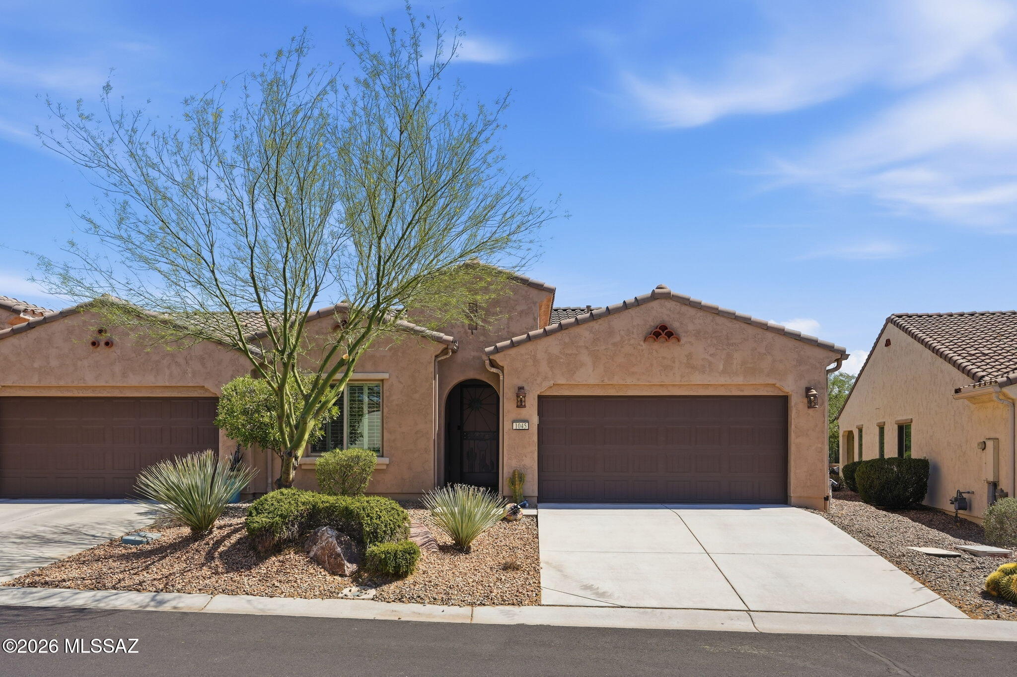 Don't miss your opportunity to own this gorgeous Cholla Villa built by Robson in the highly sought-after active adult resort community of Quail Creek. Whether you are looking for a full-time residence or a true lock-and-leave winter retreat, this home offers the perfect blend of comfort, convenience, and carefree living. Unlike current new construction opportunities, the HOA maintains the exterior of the home, including landscaping, exterior paint, pest control, and even the roof, allowing you more time to enjoy the exceptional lifestyle Quail Creek is known for. From the moment you arrive, you will appreciate the home's beautiful curb appeal. An elegant designer security door welcomes you and allows fresh air to circulate through the home during Arizona's beautiful fall and spring seasons The spacious two-car garage provides ample room for your vehicles while still offering space for a golf cart, the preferred mode of transportation for many residents within the community. Step inside and discover a home that feels virtually brand new. Meticulously maintained, the interior showcases attractive tile flooring throughout the main living areas, complemented by plush carpeting in the bedrooms and den. The upgraded cabinetry offers thoughtful storage features designed to make everyday living easier, while the modern stainless-steel appliances are sure to impress the chef of the household. The kitchen serves as the heart of the home with its large granite-topped island featuring an undermount sink, dishwasher, and convenient breakfast bar seating. It is the perfect place to enjoy your morning coffee, catch up on emails, or gather with friends while preparing meals. Adjacent to the kitchen is a spacious dining area that creates an effortless flow between indoor dining and outdoor entertaining. Designed around a highly desirable great room concept, this home allows everyone to remain connected regardless of where they are. The comfortable living area is ideal for hosting neighbors, enjoying family gatherings, or simply relaxing while watching your favorite television show or movie. Large windows fill the home with abundant natural light while ceiling fans provide year-round comfort and air circulation. The primary suite serves as a peaceful retreat and offers plenty of room for your furnishings. The en-suite bathroom features dual cultured granite vanities, a large mirror, and a beautifully tiled walk-in shower complete with a decorative accent band and niche for your personal care products. The spacious walk-in closet keeps clothing organized and easily accessible while maintaining a clean, uncluttered appearance. Your guests will feel right at home as well. The guest bedroom and bathroom provide the same level of comfort and quality found throughout the home. Accommodations this nice and a community this impressive may have your visitors extending their stay. Outdoor living is equally inviting. The covered patio features attractive paver flooring and a large, recessed area that is ideal for an outdoor living room arrangement. This private setting allows you to relax while enjoying the mature landscaping and the many local birds that frequently visit the area. It is the perfect place to unwind with a morning cup of coffee or an evening beverage while taking in Arizona's beautiful weather. Beyond the home itself, Quail Creek offers a lifestyle that is second to none. Residents enjoy access to countless clubs, social groups, and activities that keep the calendar full year-round. The community's exceptional restaurant overlooks a picturesque lake and golf course, providing a wonderful setting for dining, socializing, and enjoying a favorite beverage. Residents also enjoy indoor and outdoor swimming pools, state-of-the-art fitness facilities, creative arts and technology centers, tennis, pickleball, walking trails, and 27 holes of championship golf. This is more than just a home--it is a lifestyle. Come experience everything this exceptional property and the resort community of Quail Creek have to offer.
