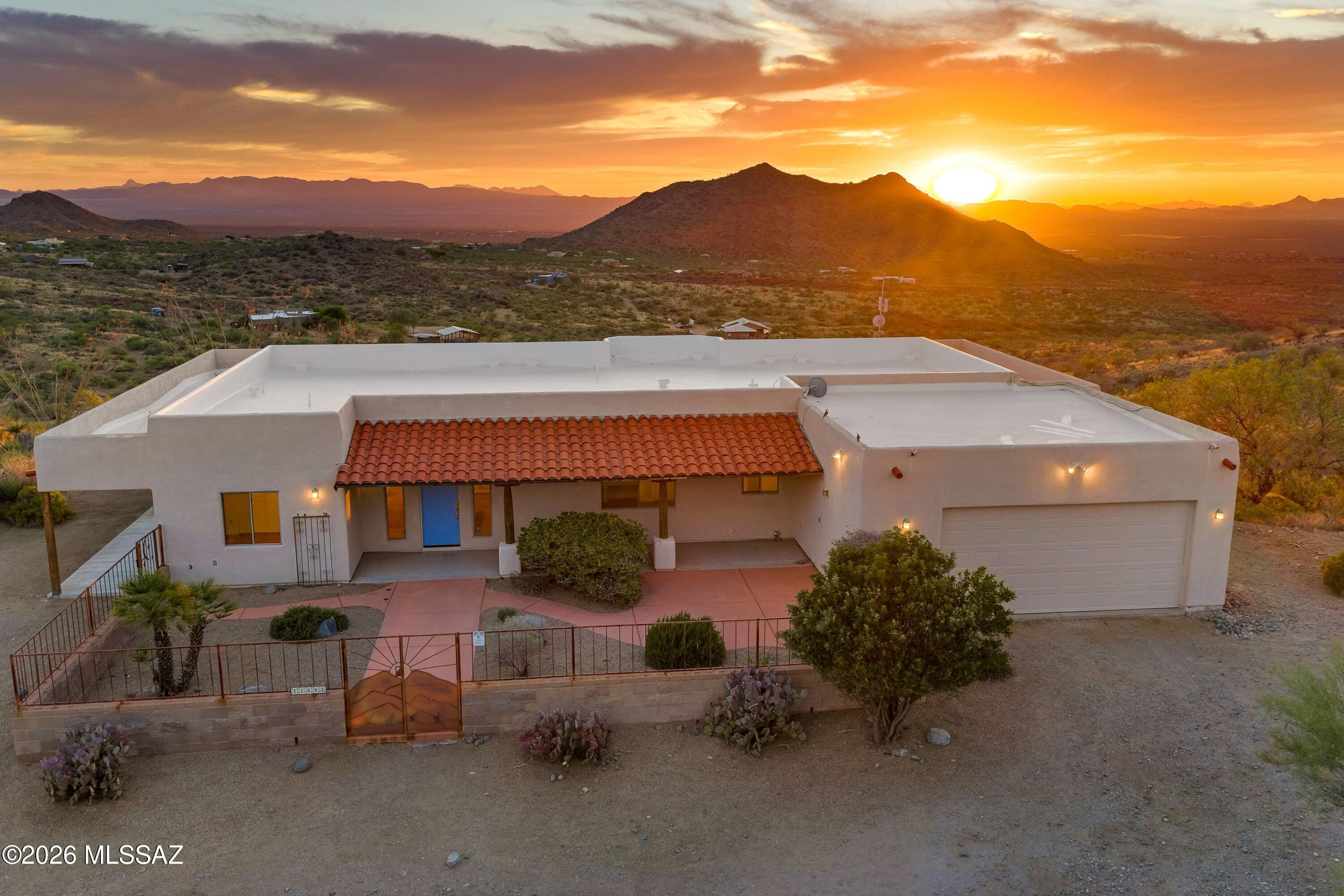 Experience desert living at its finest in this stunning ridge-top retreat nestled on 9.77 private acres adjoining State Land near the Coronado National Forest. Perched at 4,200 feet in elevation, this exceptional home showcases breathtaking panoramic views of mountain ranges, dramatic sunsets, sparkling city lights, and the lush Sonoran Desert from every room. Only 40 minutes to downtown Tucson, and just 25 minutes to Rita Ranch shopping. Spacious open-concept living filled with natural light great room opens to covered patios creating the perfect indoor-outdoor lifestyle. Quality craftsmanship is evident throughout with custom cabinetry, solid wood doors, tile flooring, and high ceilings that enhance the home's timeless Southwestern character. Block and wrought iron gated courtyard. And.. Enter through the courtyard or the oversized garage, this split-bedroom floor plan offers exceptional privacy, featuring a spacious primary suite with direct patio access, a walk-in closet, dual vanities, and tranquil desert and mountain views. Two guest bedrooms also enjoy access to wraparound patios, providing seamless indoor-outdoor living and inviting spaces to relax and take in the surrounding natural beauty. One large bedroom off great room is perfect for an office with two closets and built-in shelving. 

Outside, enjoy native desert landscaping, abundant wildlife, and unmatched privacy in a breathtaking setting surrounded by protected land and endless opportunities for hiking and exploration.
A rare opportunity to own a secluded mountain sanctuary just minutes from town, where breathtaking scenery and tranquility await every day.
Lovingly maintained as a seasonal residence, this home has been occupied only a few months each year and shows exceptional pride of ownership. Recent improvements include a brand-new roof upgraded with 3-inch Polyiso insulation board for enhanced energy efficiency and comfort, as well as a newer HVAC system installed just three years ago. Also includes the fire suppression system.

The 9.77 Acres is including the adjacent vacant land parcel at 12687 E. Enchanted Trail. The property also benefits from a Dakota Pro Repeater Site lease agreement, which provides free internet service and generates over $300 per month in supplemental income for the owner.

The property is served by a 3,000-gallon water storage system supplied by Tucson Bulk Water, a common and reliable water source for homes in the area. For buyers seeking additional options, neighboring properties have successfully drilled private wells.