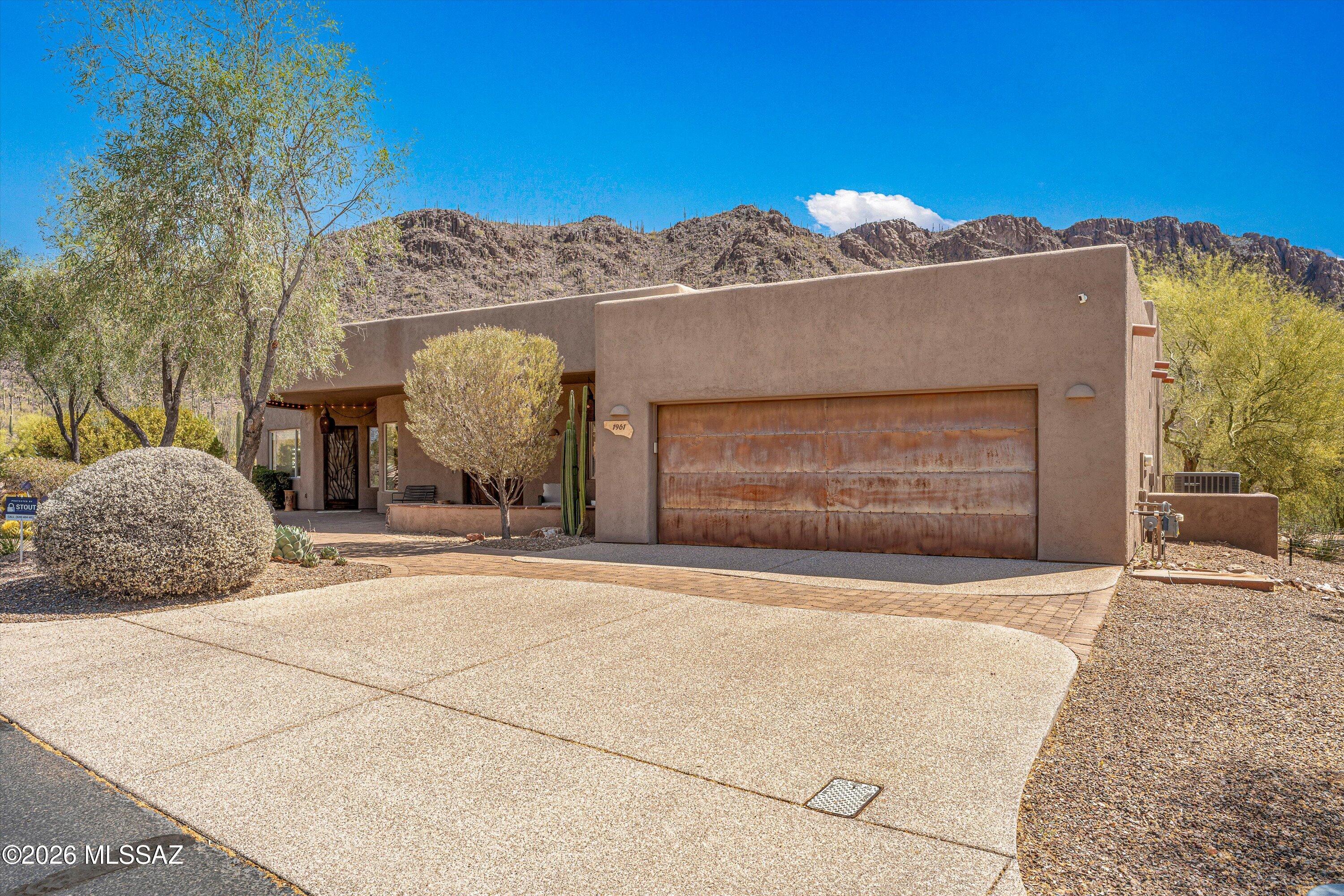 This is more than a home--it is a statement of quality, comfort, and elevated desert luxury at the base of the Tucson Mountains! Presenting a rare opportunity to own one of the most distinguished residences in Tucson Estates, masterfully built by renowned craftsman John Herder. Perfectly positioned on a premier cul-de-sac lot backing to protected open space, this exceptional property captures sweeping, unobstructed views of the majestic Tucson Mountains and the surrounding Sonoran Desert landscape.
Encompassing  2,724 total sq ft this thoughtfully designed Home offers 3 bedrooms and 2 bathrooms, plus a den/media room- designed to also function beautifully as a 3rd bedroom. In addition, the attached private studio-style Guest Quarters, complete with its own entry, and flexible open Bedroom/living space PLUS full bath offers exceptional adaptability as luxurious quarters, a refined home office, or an executive retreat.
Guest quarters also has an additional back entry door with direct patio access for full outdoor enjoyment!
Inside, sophisticated desert elegance meets superior craftsmanship. High-quality engineered Hardwood flooring flows seamlessly throughout, complementing solid wood interior doors and rich knotty alder cabinetry against the fresh bright interior. Your chef's kitchen is both striking and functional, showcasing chiseled-edge granite slab countertops, an island with bar seating, a stylish tile backsplash, a vegetable sink with disposal, and premium stainless steel appliances including a professional-grade refrigerator and Dacor oven with warming drawer.
An airy Great room designed for both grand entertaining and intimate evenings provides a modern open-concept living space. Featuring expansive windows that frame breathtaking mountain vistas. Natural light pours into the adjacent dining area, creating a warm yet sophisticated ambiance. Unique chandeliers elevate the spaces and provide a sense of distinction.
Your primary suite offers direct patio access, inviting tranquil mornings and sunset evenings against a dramatic desert backdrop. Primary ensuite complete with Travertine shower and spacious walk-in closet.
A gorgeous, fully remodeled hall bath completes the spaces.
Outdoor living is equally impressive! The northeast-facing rear yard is designed for year-round enjoyment, featuring an expansive covered patio, built-in gas fireplace, custom wrought iron view fencing, and uninterrupted views across protected nature. - Cat Mountain is just off to the right! This is Arizona living at its finest- private, peaceful, and picturesque.
Additional enhancements include new floors, 4" baseboards, interior paint, updated bathrooms, counters and backsplashes, lights fixtures, custom Roman shades, a new main house AC (2022), water softener, insulated garage doors, extensive lighting, decorative metal screen doors, and rear rain gutter system.
Residents enjoy resort-like living within this upscale gated community, including access to pool and spa facilities, Pickleball courts, clubhouse amenities, and the beautifully maintained Tucson Estates Golf Course. HOA also provides secured RV parking(based on availability). Just moments away, the extensive trail system of Tucson Mountain Park/Gates Pass offers miles of hiking, biking, and breathtaking desert exploration. Mountain View trail is just right off the cul-de-sac! Close proximity to Old Tucson, AZ Sonoran Desert Museum, Saguaro National Park West plus easy access to Ajo Hwy, I-19 & I-10.