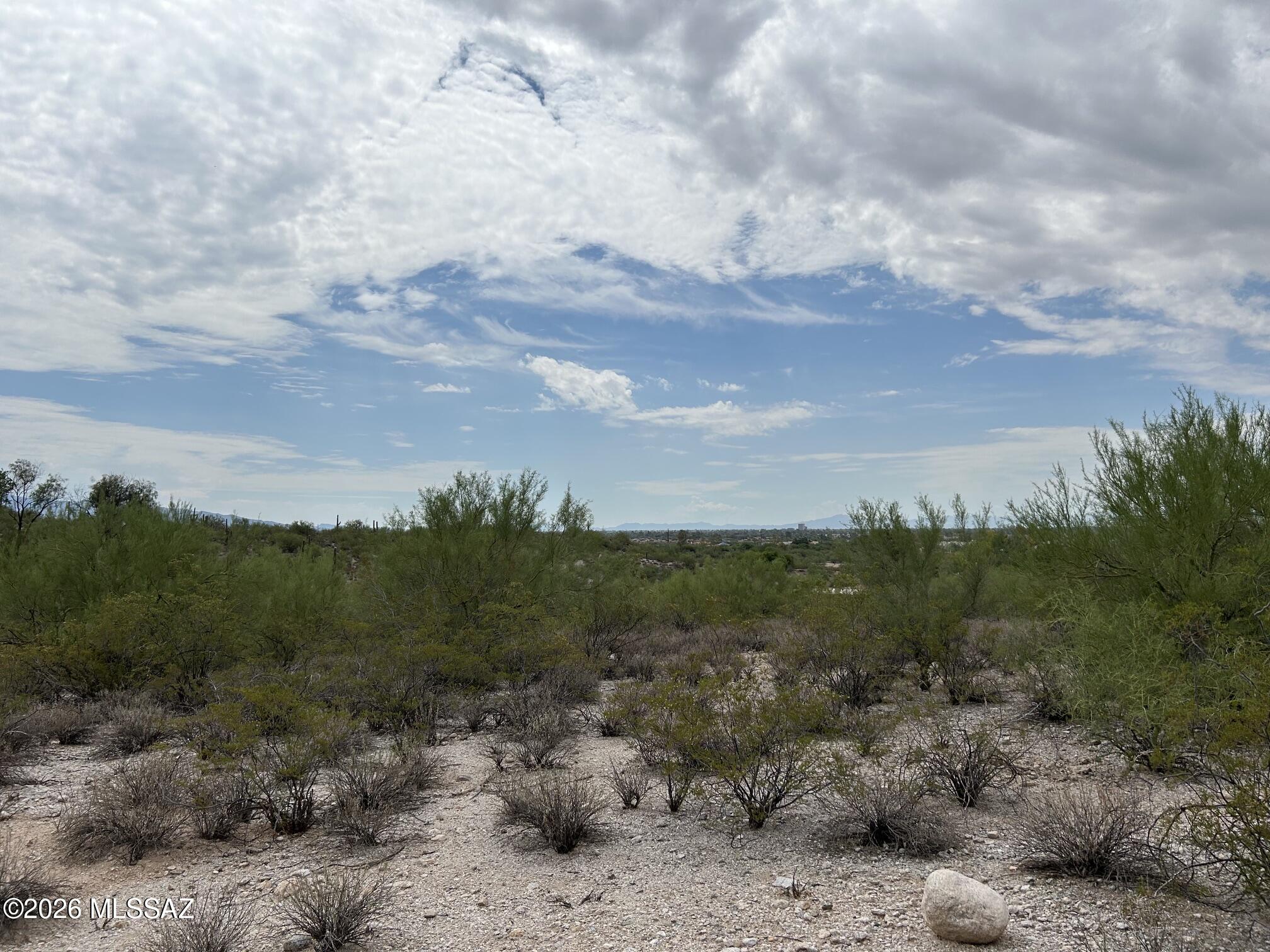 VERY RARE, UNSUBDIVIDED, 4.9 acres in the LOWER FOOTHILLS on a HIGH FLAT and GENTLY SLOPED RIDGE with SPECTACULAR VIEWS of the TUCSON VALLEY. Partial Catalina Mtn Views as well. NO CCR'S or HOA for great flexibility of what and when to build. Plenty of room to grade the lower of the lot for your horses and well separated from your house pad up high. Private driveway is shared with neighboring $2.5 Million home. Served by Tucson Water. electric. phone and natural gas. Wonderful. CENTRAL LOCATION with easy access to the U of Area as well as the FOOTHILLS.  No signs. Call Listing Agents to meet onsite.