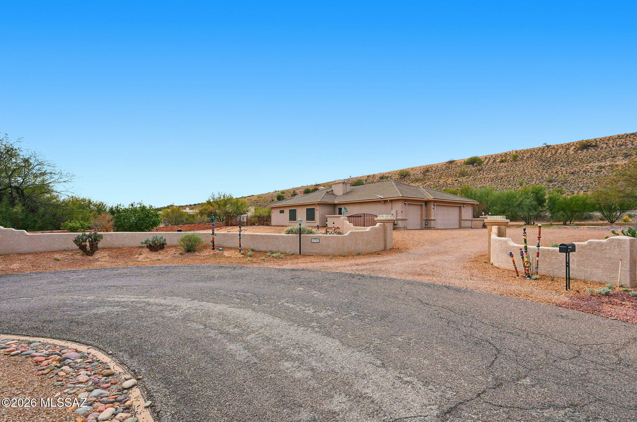 Welcome to a beautiful custom home in a quiet cul-de-sac with no GVR & a very low HOA!! A serene and peaceful desert setting that is one of the best that Sahuarita offers. I think you're going to love this house! Let's start with an expansive lot that's over 1.3 acres. It has a LARGE backyard that has been paved, is covered, has an outside wet bar, and has been completed with a removable fence that separates the LARGE side yard that is ready for your imagination. You've already got 220v wiring and gas hookups out back! Not to mention very easy care, with drip systems throughout all yards so you don't have to stress. Two HVAC units have been recently replaced, one in 2023 and the other in 2025. The home features a grand gourmet kitchen with a 5 burner stove, island, a breakfast bar, and plenty of counter space and cabinets to cook some epic meals. The primary bedroom and bath are HUGE, with dual closets and opposing vanities. Jetted tubs in both full baths will allow you to unwind in the best way. There are a multitude of fruit trees on the property, including two lemon, a peach, a nectarine, a pomelo, and an orange tree. Other trees and easy care make this an absolutely beautiful desert landscape, with your property line extending far past the walls providing a nice buffer between your friendly neighbors. A 3-car garage gives you plenty of space with extended areas for storage, work spaces, and creative opportunities to make the home perfect for you. A courtyard in the front with natural grass allows you to take in yet another special setting of easy peaceful living. The front drive is landscaped with decorative rock that allows for a ton of parking so feel free to invite your neighbors and friends, play some great music, and entertain your hearts out. Peaceful, unique, and a vast playground to enjoy the natural beauty of Southern AZ, this home is going to wow you. Schedule a showing or secure your own private tour before this is gone. I truly think you'll see the love and passion that the owners have given and gone on to enjoy in this home.