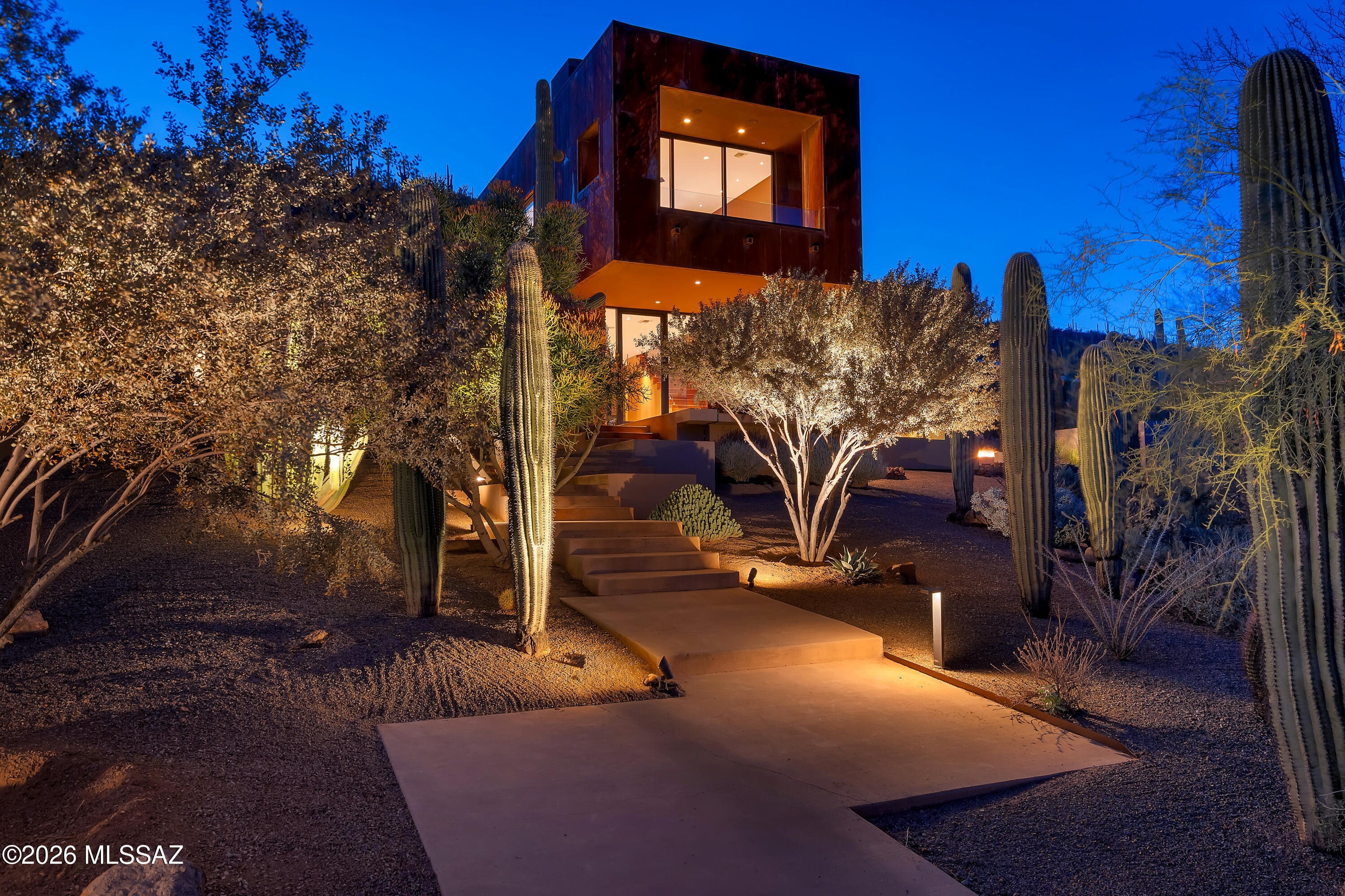 Set on a private ridge in the Tucson Mountains, this architect-designed contemporary home spans 3.3 secluded acres with over 300 mature saguaros and unobstructed views of five mountain ranges. Floor-to-ceiling glass captures sweeping desert vistas from every room. Expansive terraces, pool, spa, and two outdoor gas fire features create effortless indoor-outdoor living. The interior includes a dual chef's kitchen with two dishwashers, dual laundry, a full-floor owner's suite, and a detached media room with whole-home audio and WiFi extending outdoors. For those who want more, approved plans provide a ready option to convert two existing spaces into a third bedroom with ensuite and a dedicated home office or gym, giving the next owner a defined path to expand the home's living program on their own timeline. Built with metal, glass, stone, concrete, and natural wood, this is a rare blend of scale, privacy, and design. No HOA. Minutes to I-10, downtown, and the airport.