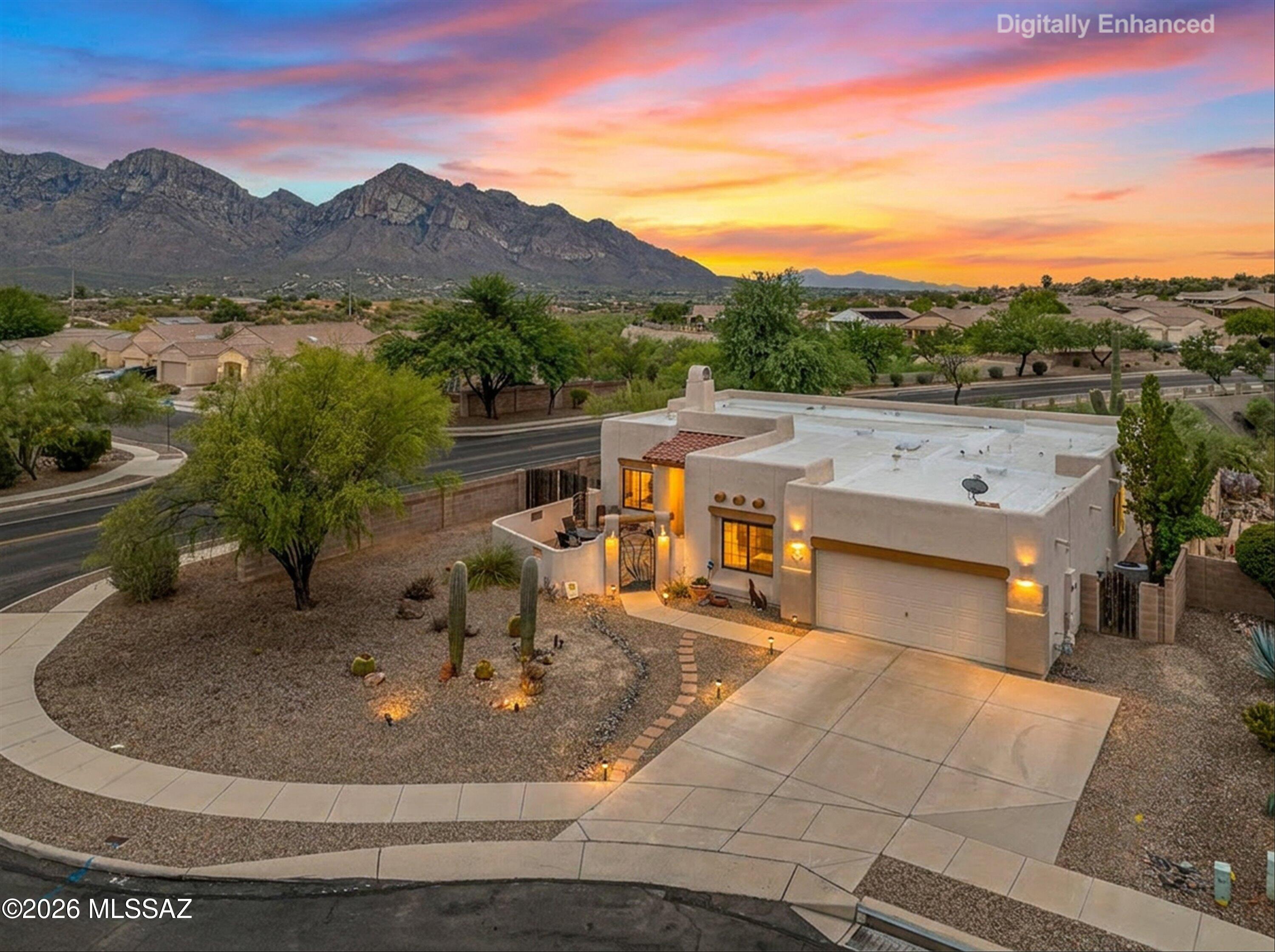 Welcome to this stunning Southwestern-style home perfectly positioned on a prime corner cul-de-sac lot with no back neighbors! This home offers the privacy, views, and serenity that desert living is all about. From the moment you arrive the mature saguaro cactus and glowing landscape lighting set the tone for something truly special, especially at sunset, when the Catalina Mountains turn golden right before your eyes.

Inside, this thoughtfully updated 3-bedroom, with a den, 2-bathroom home offers a warm and inviting layout designed for both everyday living and effortless entertaining. The open-concept family room features high ceilings, rich hardwood-style flooring, and a cozy tile-surround fireplace.

The heart of the home is a beautifully updated kitchen. Granite countertops, painted cabinetry, a dark slate tile backsplash, and stainless steel appliances create a sophisticated yet functional workspace. A stunning copper farmhouse sink anchors the window overlooking the beautiful backyard, while the oversized two-tone island provides generous prep space, additional storage, and a natural gathering spot for family and friends.

The primary suite is a true retreat, featuring direct access to the back patio, views of the backyard, and a spa-inspired ensuite bath complete with a walk-in shower accented by river rock tile, a soaking tub, and a walk-in closet with built-in shelving.

Stepping into the backyard you'll discover your own private desert oasis. With no back neighbors, the backyard feels expansive and peaceful -- a paver patio, mature saguaro, lush garden, and a fire pit seating area all frame breathtaking mountain and sunset views that never get old.

This is more than a home -- it's a lifestyle. Don't miss your opportunity to own this one-of-a-kind property in one of Tucson's most desirable settings.