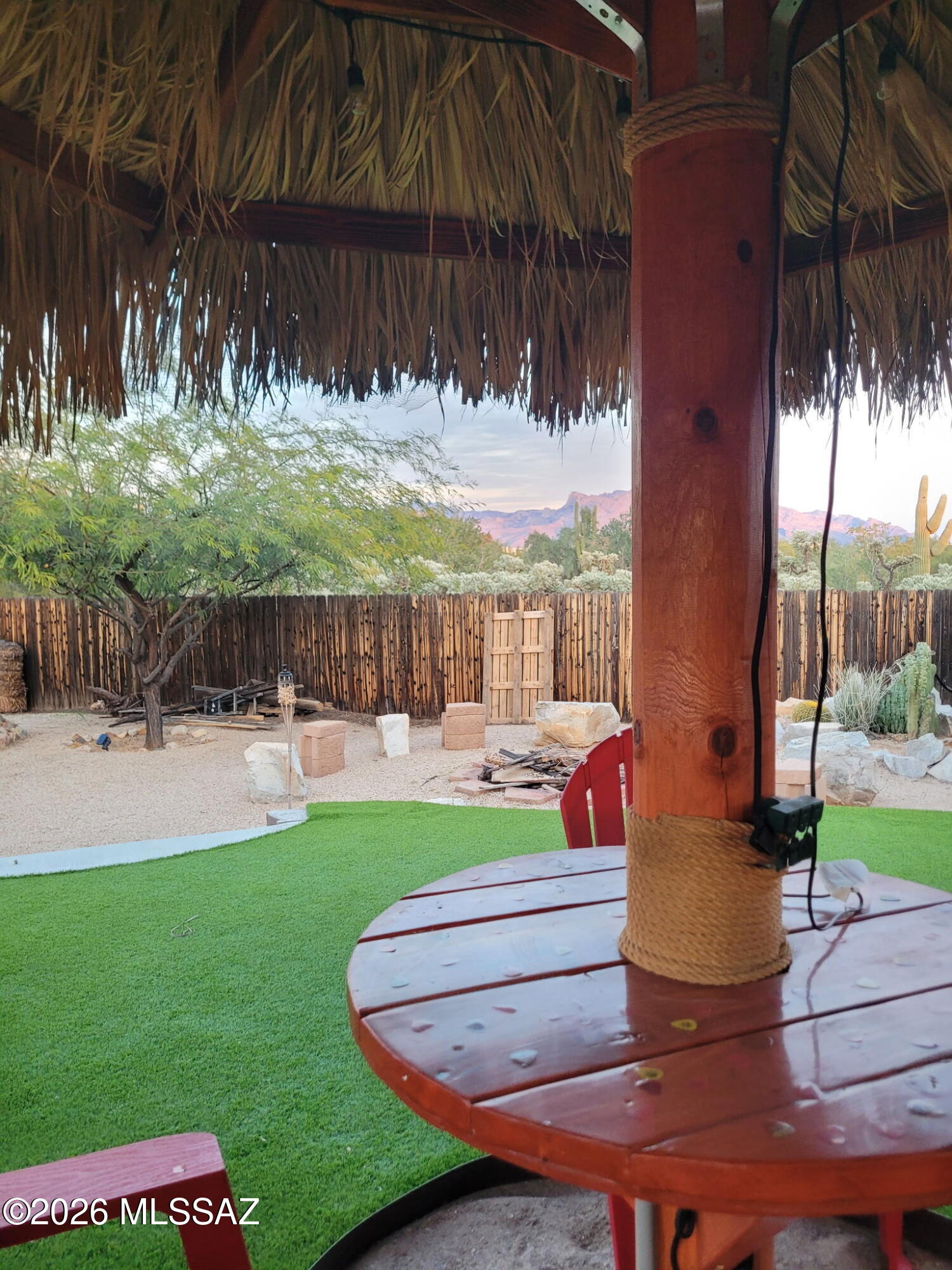 AWESOME Setting perfect for entertaining! Luscious backyard with custom Palapa w/electric & water, DEEP fire pit surrounded with boulder chairs, 50 amp Jacuzzi plug available, PRIVATE, Covered Patio, Brick paver patios, fenced, 3 Elevated garden beds and Mountain Views. Property abuts Pima County Conservation area to the east. Situated at the end of the street, room enough to park your RV with a 50 Amp RV hook-up underneath electric panel 25 feet away. NO HOA! Inside features include cozy living room with fireplace, updated baths. Tile floors thru-out. Fresh Exterior Paint OWNED SOLAR! New HVAC compressor installed 2024. New Roof Installed .2022.