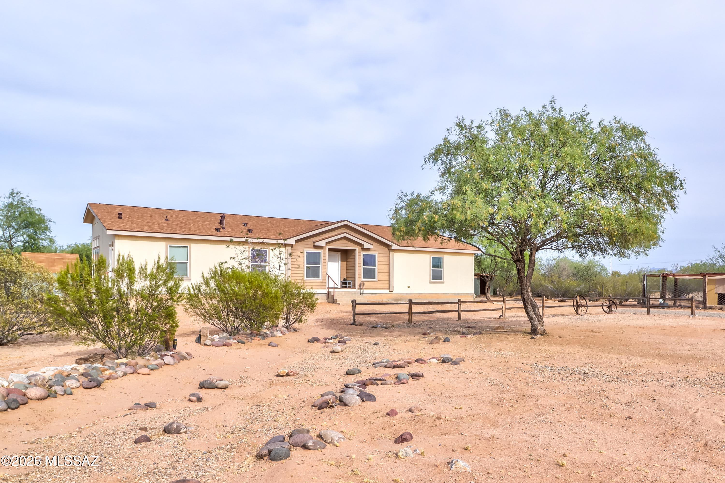 Welcome home to Marana, and live the desert dream freely in this triple-wide MFSR. Built in 2009, this spacious home features a formal living and dining room; a large kitchen with breakfast bar and nook; and an adjoined family room. The massive owner's suite has a large closet, attached den, and an en-suite bathroom with two vanities, a garden tub, separate shower, and water closet. Additionally, there are 2 guest bedrooms, a guest bathroom, powder room and large laundry room. All 6 of the new exterior doors are custom. Outside, there is a 2-car garage/workshop, storage shed, open storage shed, and a dog run. The property sits just off paved roads with just a short run on a dirt road. Enjoy the acre of land, beautiful sunset skies and mountain views at an affordable price. Come. See. Stay! Enjoy the acre of land, beautiful sunset skies and mountain views at an affordable price. Come. See. Stay!