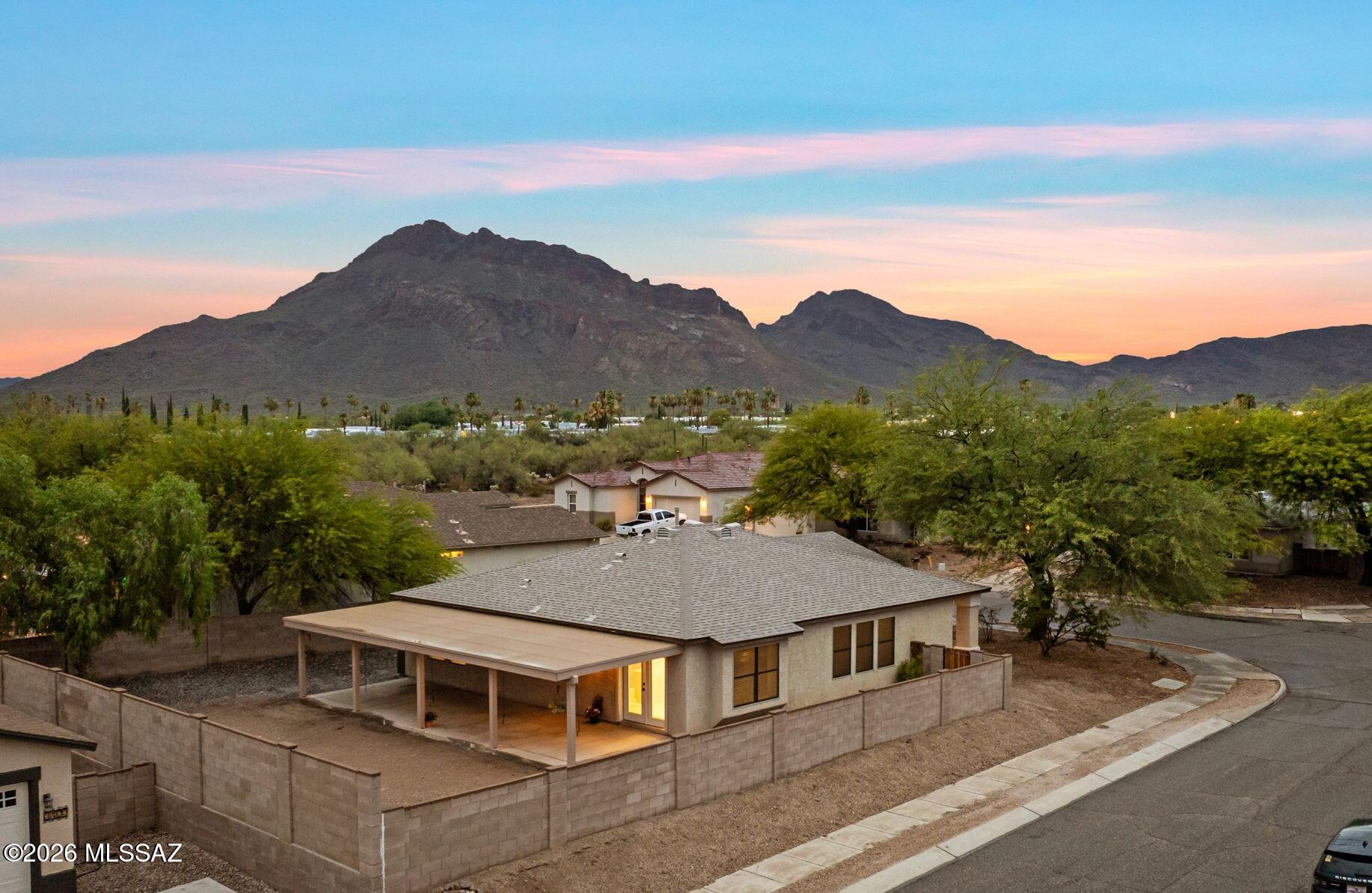 Discover this west-side gem at the base of the Tucson Mountains! Situated on a desirable corner lot with mountain views, this home offers an extended covered patio spanning the length of the home and a spacious backyard ready for your personal touch. Enjoy peace of mind with a new roof (2024), new water heater, HVAC surge protection, main water line replaced (2022), exterior solar shades, fresh interior paint, and wood-look ceramic tile throughout the main living areas. Mature trees, front drip irrigation, and a low-maintenance yard make everyday living easy. Minutes from Tucson Mountain Park, Old Tucson, Gates Pass, downtown, the University of Arizona, Raytheon, and Tucson International Airport, this home blends comfort, convenience, and outdoor adventure. With 2.37% assumable VA Loan!!