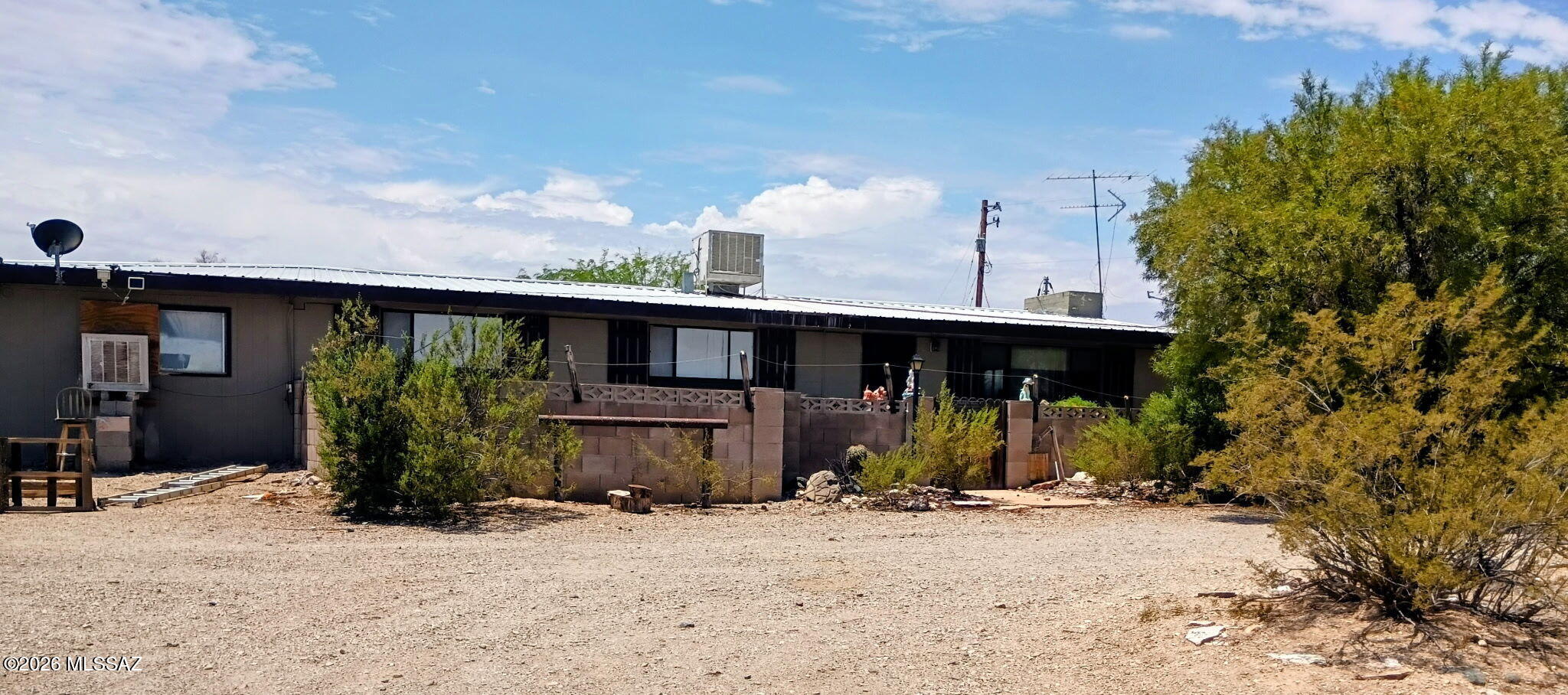 Discover the possibilities with this well-built home on a spacious 3.9-acre lot on Tucson's desirable West Side. The property features a 3-bedroom, 2-bath main residence plus attached 1-bedroom, 1-bath guest quarters, each with its own kitchen and living area--ideal for multigenerational living, guests, or rental potential. Step outside to a large backyard with a covered patio, a fenced area perfect for horses, chickens, or recreational vehicles, and plenty of room to create your dream outdoor space. An owned solar system helps keep energy costs low while adding long-term value. Take in breathtaking 360-degree views of the Tucson Mountains, sparkling city lights, and the stunning Catalina Mountains from this unique desert retreat. With acreage, flexibility, and incredible scenery, this.... .... property is ready for your vision.