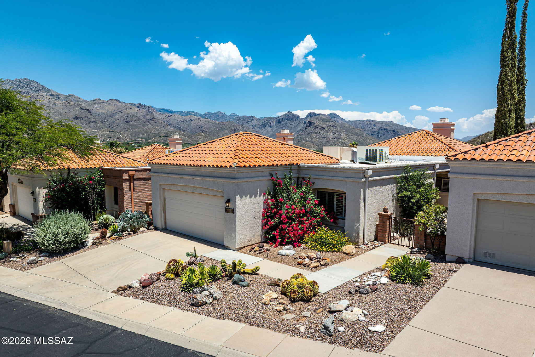 Views, Views, Views! Perched on one of the premier lots in the community, this beautiful Catalina Foothills home captures breathtaking Catalina Mountain, valley, and sunrise views that will impress from the moment you arrive. Located in a highly desirable upscale area, this is a rare opportunity to own a single-family home in the Catalina Foothills at this price point. The bright and open floor plan features soaring ceilings, abundant natural light, custom wood shutters, ceiling fans, and two spacious living areas centered around a stunning two-way gas fireplace. The expansive family room offers direct access to the covered patio, creating seamless indoor/outdoor living and entertaining. The second living room showcases the opposite side of the fireplace, providing additional space to relax and enjoy the views.
The kitchen is designed for both functionality and gathering, featuring a stainless steel gas range, built-in microwave, stainless steel side-by-side refrigerator with water and ice dispenser, dishwasher, tiled countertops, abundant cabinetry, and bar seating for three.
Retreat to the spacious primary suite through double-door entry doors. The ensuite bath offers double sinks with an extended vanity, a relaxing garden tub, and a generous walk-in closet.
Outdoor living is exceptional with a large wraparound covered patio, extended brick paver patio areas, a front gated courtyard, wrought iron security door, and professionally landscaped grounds showcasing beautiful decorative ironwork and an abundance of rare decorative rock features.
Additional highlights include a newer water heater, an oversized two-car garage with extensive built-in storage cabinets, and access to community amenities including a pool, spa, covered ramada, and walking paths.
Ideally located within walking distance to grocery stores, restaurants, and shopping, and just minutes from Sabino Canyon, Ventana Canyon, world-class golf courses, luxury resorts, hiking and biking trails. Located in the highly acclaimed District 16 school district.
Experience the perfect combination of spectacular views, convenience, and Catalina Foothills living.