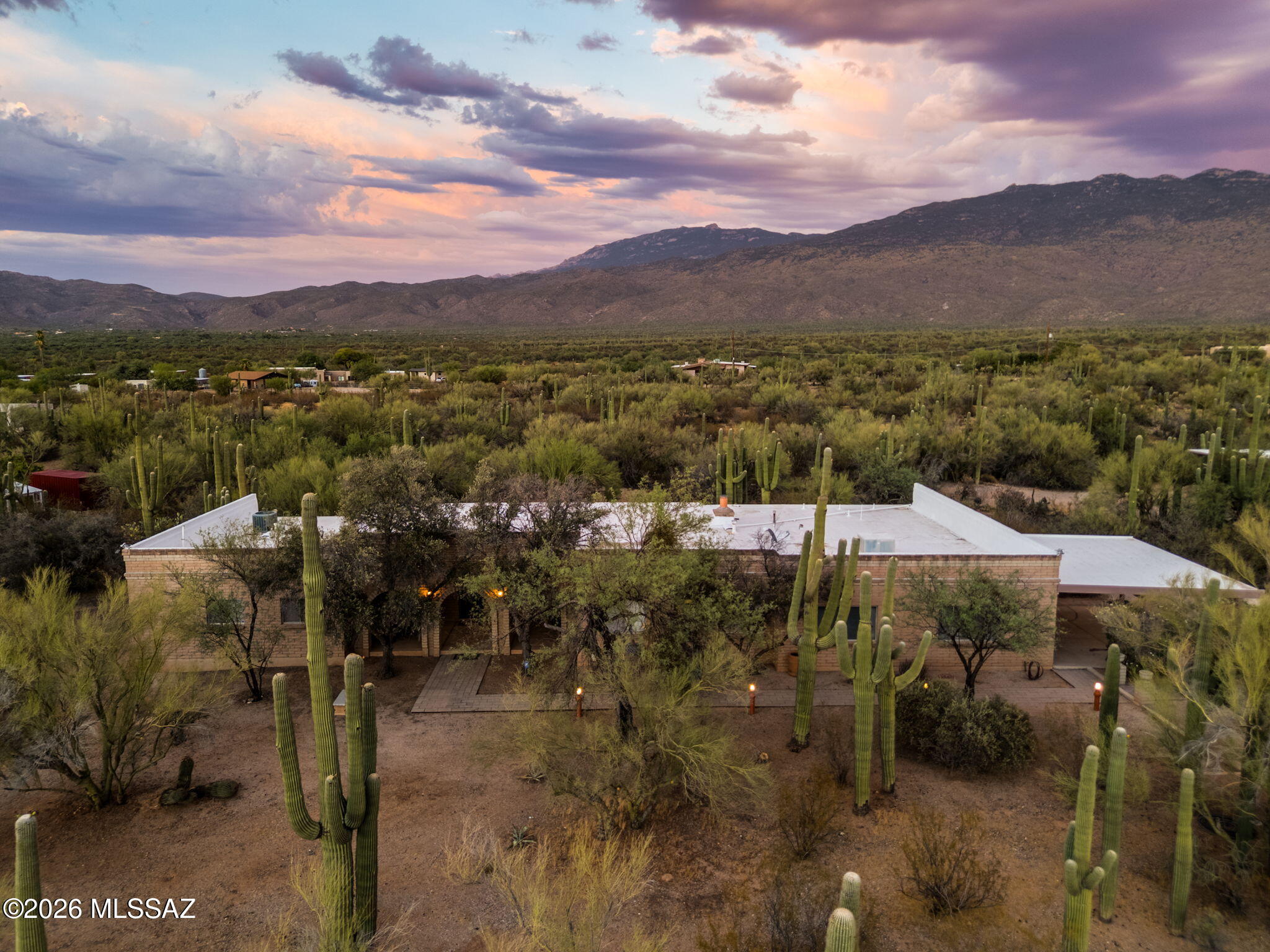 Experience authentic Tucson living on this stunning 4.7-acre desert estate, adjacent to Saguaro National Park with breathtaking mountain views and direct access to hiking and riding trails. Surrounded by lush Sonoran Desert landscaping, this sprawling 6-bedroom, 4-bath ranch-style home is designed for comfort, privacy, and flexible living. The thoughtfully designed split floor plan is ideal for multigenerational households, while expansive windows fill the living room with natural light and frame spectacular desert and mountain vistas. At the heart of the home, a charming wood-burning fireplace is complemented by a full wall of built-in bookshelves, creating a warm and inviting gathering space with timeless Southwestern character.The detached full guest house, complete with its own laundry offers exceptional versatility for extended family, guests, or potential short-term rental income. Additional highlights include ample storage, generous outdoor space, and endless opportunities to personalize the property to your taste. Offering the privacy and tranquility of the desert while remaining close to Tucson's outdoor recreation, this classic one-story ranch embodies the best of Arizona living. Wake up to sweeping mountain views, enjoy unmatched serenity, and make this exceptional desert retreat your own.