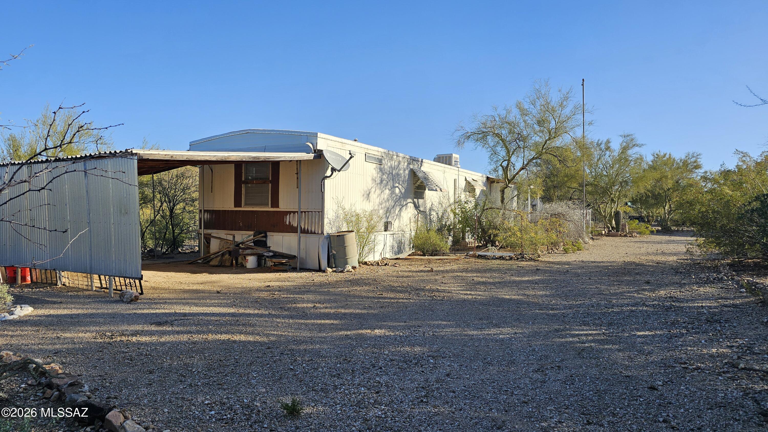 Fixer-Upper Special! Sitting on 1.54 acres this property offers space and opportunity! Zoned Gr-1, this property allows for limited agricultural and livestock options (buyer to verify). Featuring a 756 square foot (affixed) manufactured home 2 BR/1.5 bath, with large carport and security lights. The home has gas heat, gas stove, and mini-split air conditioner (not tested, buyer responsible for any utility activation). There is also a large (1000+ sf) workshop w/ electric and concrete floor. Property has multiple areas of deferred maintenance and is priced accordingly low. CASH or HARD MONEY LOAN TRANSACTION ONLY-Not eligible for financing. Caution: no hand rail and uneven landing surfaces.