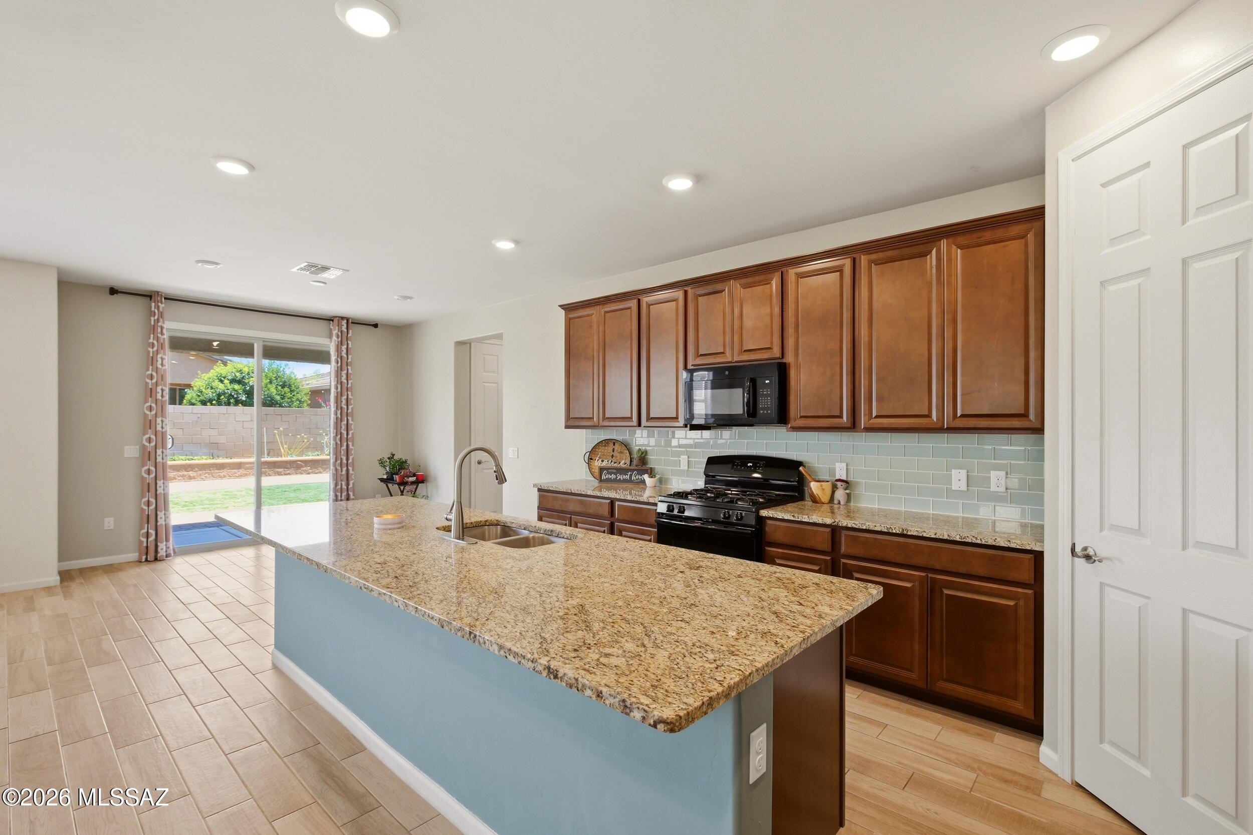 Welcome to this spacious and beautifully designed 4-bedroom + den, 3- full bathroom home in the highly sought-after Vail community! Designed with both everyday living and entertaining in mind, this two-story home features an open-concept floor plan with generous living spaces throughout. The heart of the home is the beautifully appointed kitchen, complete with a large center island that's perfect for hosting family gatherings, entertaining guests, or enjoying casual meals. The kitchen flows seamlessly into the open living area, creating a warm and inviting space for making memories. A downstairs bedroom and full bathroom offer the perfect setup for guests, multi-generational living, or added privacy. You'll also find a versatile den on the main level that's ideal for a home office, playroom, or flex space. Upstairs, a spacious loft provides an additional living area, while the generously sized bedrooms offer comfort for everyone. The oversized primary suite serves as a private retreat with plenty of room to relax and features a large walk-in closet. Step outside to the expansive backyard with low-maintenance turf, offering ample space for entertaining, kids and pets to play, or simply enjoying Arizona's beautiful weather. Located in the award-winning Vail School District, this home is nestled in a community packed with exceptional amenities, including pools, a splash pad, tennis and pickleball courts, parks, playgrounds, and scenic walking trails. This home offers the perfect combination of space, functionality, and an unbeatable community--ready for you to move in and enjoy!
