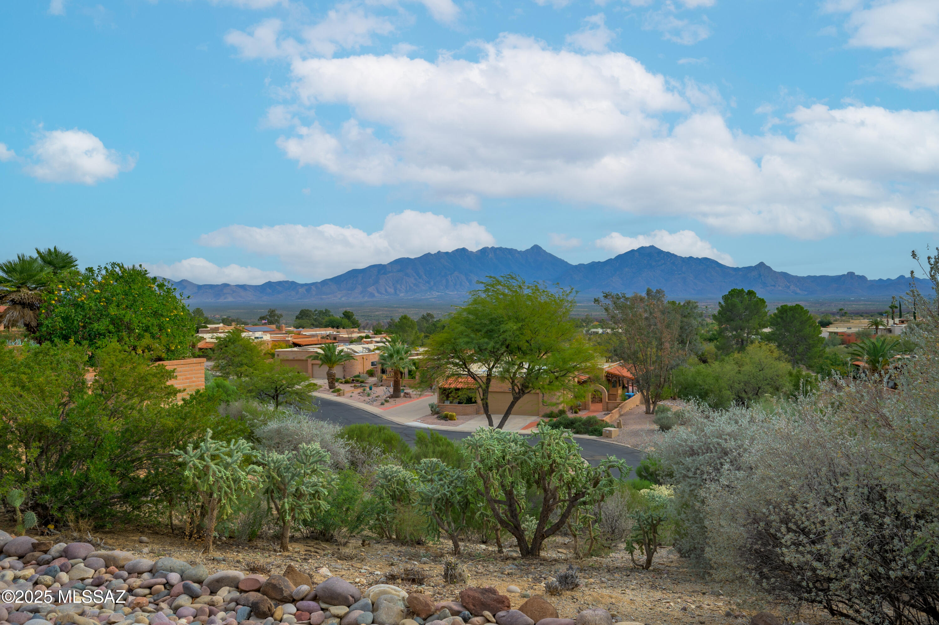 Welcome to 937 W Desert Hills Drive, where comfort, space, and breathtaking Santa Rita Mountain views come together in one of Green Valley's most sought-after neighborhoods, Desert Ridge. From the moment you arrive, you'll feel the charm. A mature grapefruit tree greets you out front, offering shade, character, and the simple joy of fresh citrus right from your own yard. Inside, this spacious 2,050 sq ft slump block home has been thoughtfully refreshed, featuring popcorn ceilings removed, a freshly repainted interior, new carpet, and a newly installed primary bathroom vanity giving the home a clean, modern feel while maintaining its warmth. The well-designed layout offers 2 bedrooms, 2 baths, and a versatile den that's perfect as a home office, hobby space, or guest area. The updated kitchen features refreshed cabinetry and countertops, while large windows fill the home with natural light, creating an inviting and open atmosphere throughout. Step outside and experience what truly sets this home apart; The unobstructed Santa Rita Mountain views that provide a stunning backdrop every single day. The expansive wraparound covered patio is made for Arizona living, whether you're enjoying quiet mornings, entertaining guests, or simply soaking in the peaceful surroundings. Located just minutes from golf courses, GVR centers, walking paths, shopping, and dining, this home offers the ideal blend of relaxation and convenience. Homes with views like this in Desert Ridge rarely come available. Come see why this is the perfect place to enjoy the best of the Green Valley lifestyle.