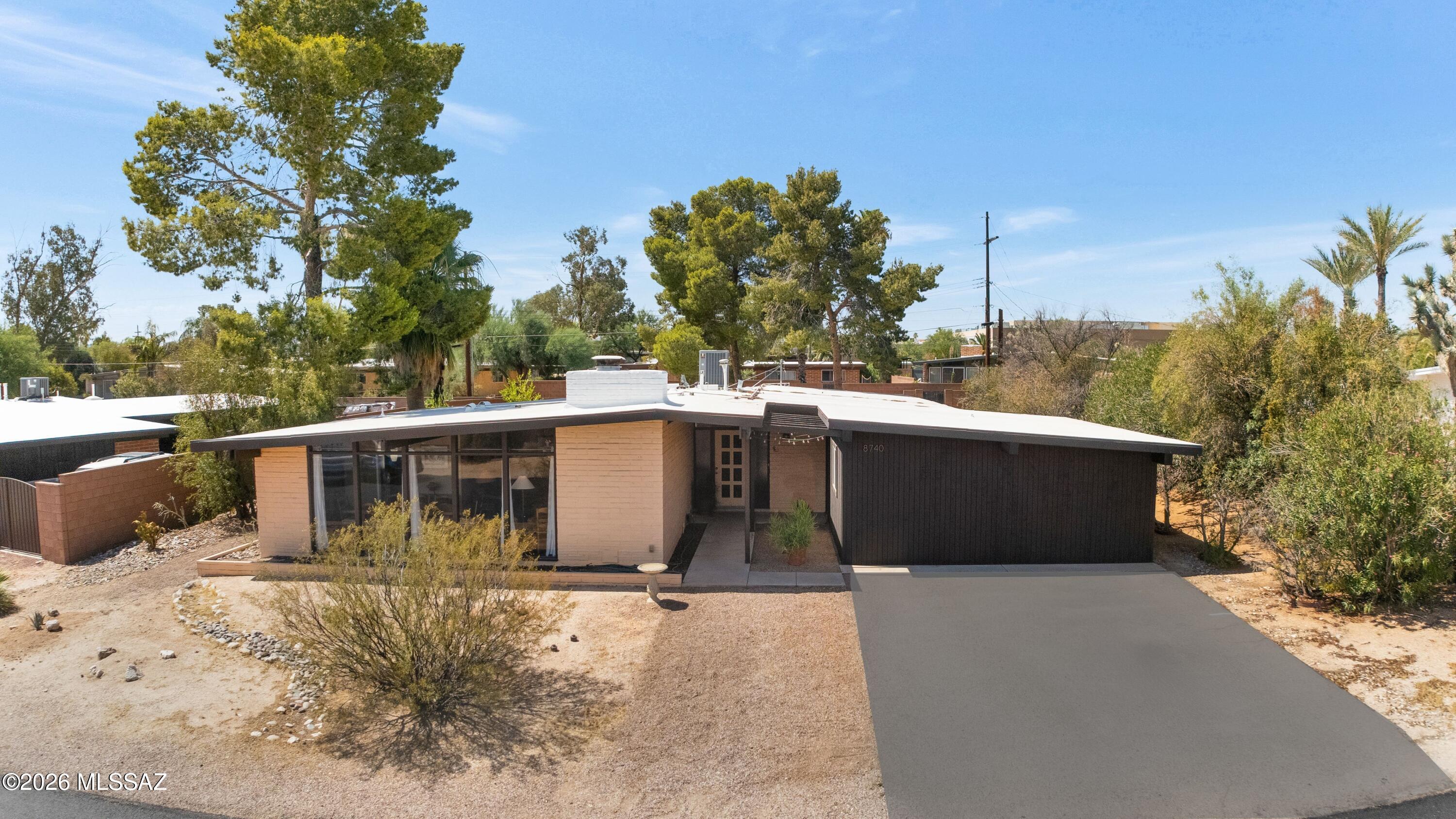 Timeless Mid-Century charm in the historic Windsor Park neighborhood. Distinctive 4-bedroom, 2-bath home filled with original character, featuring dramatic floor-to-ceiling windows, vintage light fixtures, concrete floors, & original Mid-Century kitchen that preserves the home's authentic architectural style. Wood-burning fireplace adds warmth & character to the living space, while expansive windows frame beautiful mountain views. The private backyard is a true retreat, surrounded by mature trees & highlighted by a sparkling pool. A secondary courtyard offers additional outdoor space & can easily function as a dog run. The home also includes a huge storage room that can be converted back into a double garage. A rare opportunity to own a character-filled Mid-Century home.