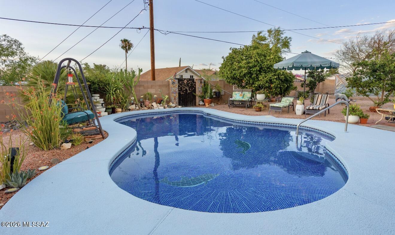 Move-in ready, well-maintained solid block home with a custom tile pool located on a corner lot and no HOA. The interior features tile flooring throughout, custom tile countertops in the kitchen, and custom cabinets and counter tops in the bathrooms, which also include tiled showers. For energy efficiency, the home is equipped with upgraded dual-pane windows.
Exterior upgrades include stucco siding, a paver driveway, and a custom block wall surrounding both the front and back of the property. The large backyard is designed for entertaining and includes several fruit trees for added privacy, as well as a greenhouse for gardening. Fully enclosed Arizona Room with a fireplace to enjoy the evenings.