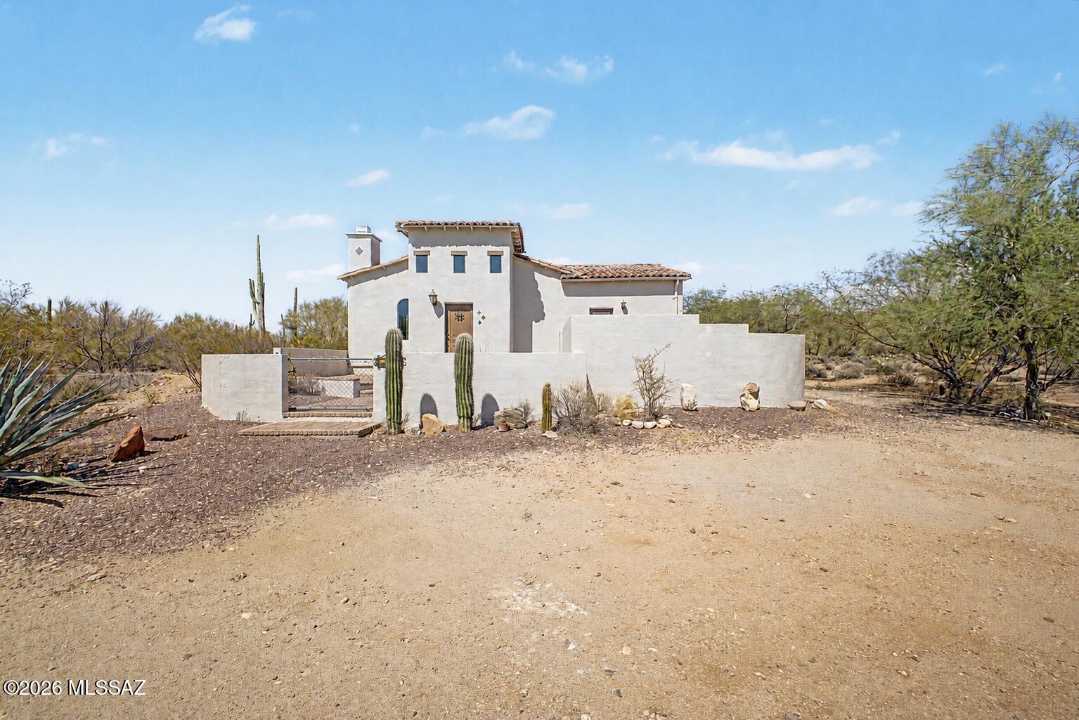 Discover the perfect blend of privacy, charm, and endless possibilities on 3 picturesque acres with breathtaking Mountain views! This Mediterranean-style 2-bedroom, 1-bath home features a tile roof, graceful archways, warm wood accents, and an inviting layout. The fully fenced front and backyard provide defined outdoor spaces for recreation, pets, and entertaining, while the expansive acreage offers room for RVs, trailers, equipment, and future projects. Complete with RV hookups and ample space for a potential second home or additional structures (subject to applicable approvals), this property offers exceptional flexibility. Enjoy the freedom of no HOA, peaceful desert surroundings, and convenient access to Marana's shopping, dining, and amenities.