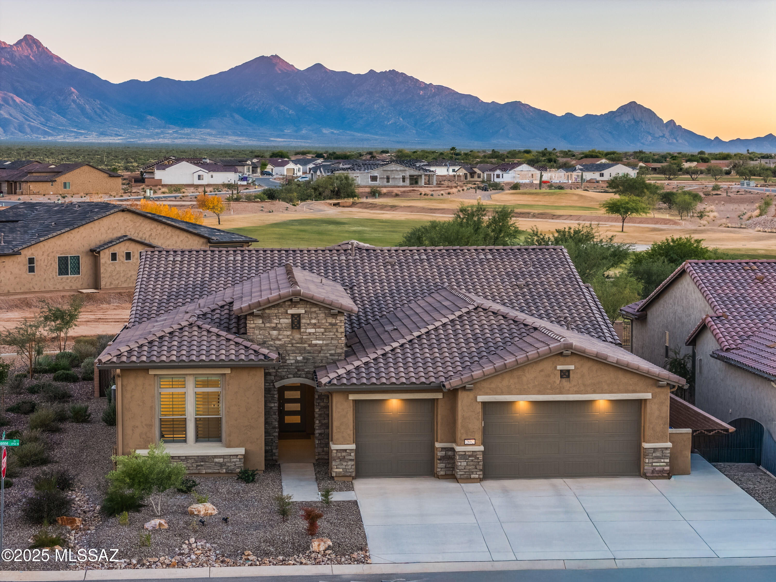 This exceptional 2024 residence presents 3 bedrooms, 2.5 baths, and 2,968
square feet of impeccably curated living within Quail Creek, one of Southern
Arizona's most sought-after active adult communities. A refined neutral palette,
elevated finishes, and thoughtful design define the home, which offers two
private en-suite bedrooms, an expansive den, and a separate executive-style
office.
The striking arrival experience features a stacked-stone facade and a dramatic
multi-panel chord-glass entry door. Inside, the open great room is both elegant
and inviting, enhanced by recessed ceilings and expansive walls of glass created
by a stackable glass door that bathes the interior in natural light. Wide-plank
luxury vinyl flooring flows seamlessly throughout, no carpet while a custom 7.1 surround-sound system and impressive 85-inch television create a true entertainment destination.
The chef's kitchen is a statement of both form and function, anchored by a generous island and outfitted with an induction cooktop, Bosch refrigerator, and built-in convection and microwave ovens. Quartz countertops, a designer tile backsplash, and premium stainless appliances are complemented by a walk-through butler's pantry connecting to an oversized walk-in pantry. The dining area enjoys a south-facing window and effortless access to the patio, creating a seamless indoor-outdoor lifestyle.
The primary retreat is a serene sanctuary featuring patio access from a south-facing sliding door, a 65-inch smart TV with Sonos Beam soundbar, and a spa-inspired bath with a dual quartz vanity, elongated custom walk-in shower, and a spacious, custom-finished walk-in closet. The guest en-suite offers equal sophistication with a 55-inch smart TV and Sonos Beam soundbar, ensuring comfort and privacy for visitors.
Additional appointments include a well-placed powder room, French doors to the office and den, crown molding, plantation shutters, recessed ceilings, designer ceiling fans indoors and out, ceiling speakers in the great room, office, and den, water softener, reverse-osmosis filtration, and a convenient stop-and-drop station adjacent to the garage. The well-appointed laundry room features a sink and newer appliances.
The insulated, extra-deep three-car garage is exceptional, featuring a mini-split HVAC system, TV, utility sink, custom cabinetry, extensive wall and overhead storage, an epoxy-coated floor, and a substantial built-in workbench with drawers. Outdoors, a generous south-facing rear patio offers a refined space for entertainment and relaxation, complete with a fireplace for year-round enjoyment.
Residents of Quail Creek enjoy an unparalleled resort lifestyle, including championship golf, indoor and outdoor pools, tennis, pickleball and bocce courts, dog park, creative arts center, on-site dining, scenic walking paths, bike lanes, and a vibrant calendar of social opportunities.