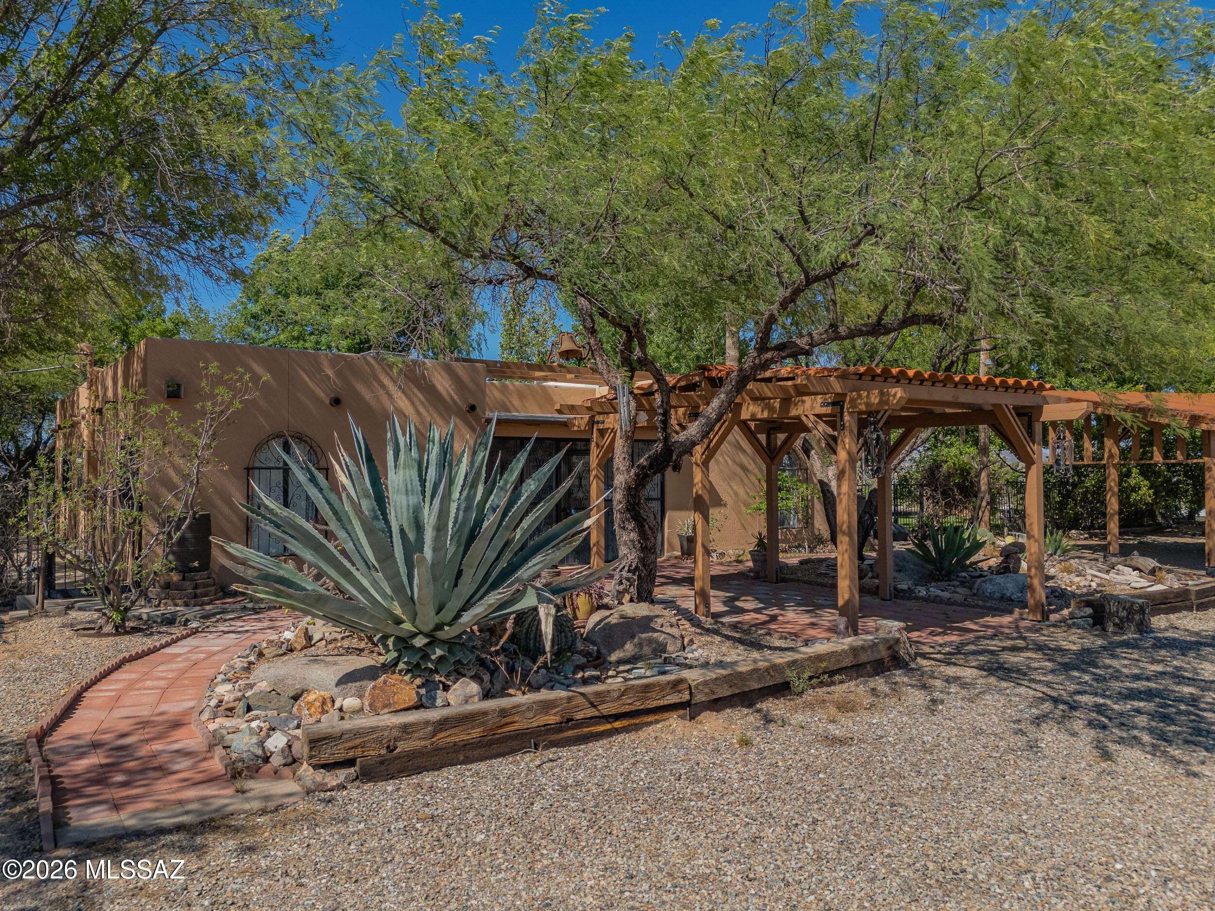 Set on approximately three acres, this private retreat offers open skies, expansive 360° mountain views, and a serene, natural setting. The home features a sunken living room with generous gathering space and a cozy fireplace, along with a large kitchen finished with travertine countertops. Outdoors is a true oasis, beautifully shaded by mature trees that transform with the seasons. Enjoy abundant fruit trees, productive garden beds, and a private sauna for year-round relaxation. With exceptional privacy, storage, and versatility, this rare property is perfectly suited as a residence, retreat, or investment.
