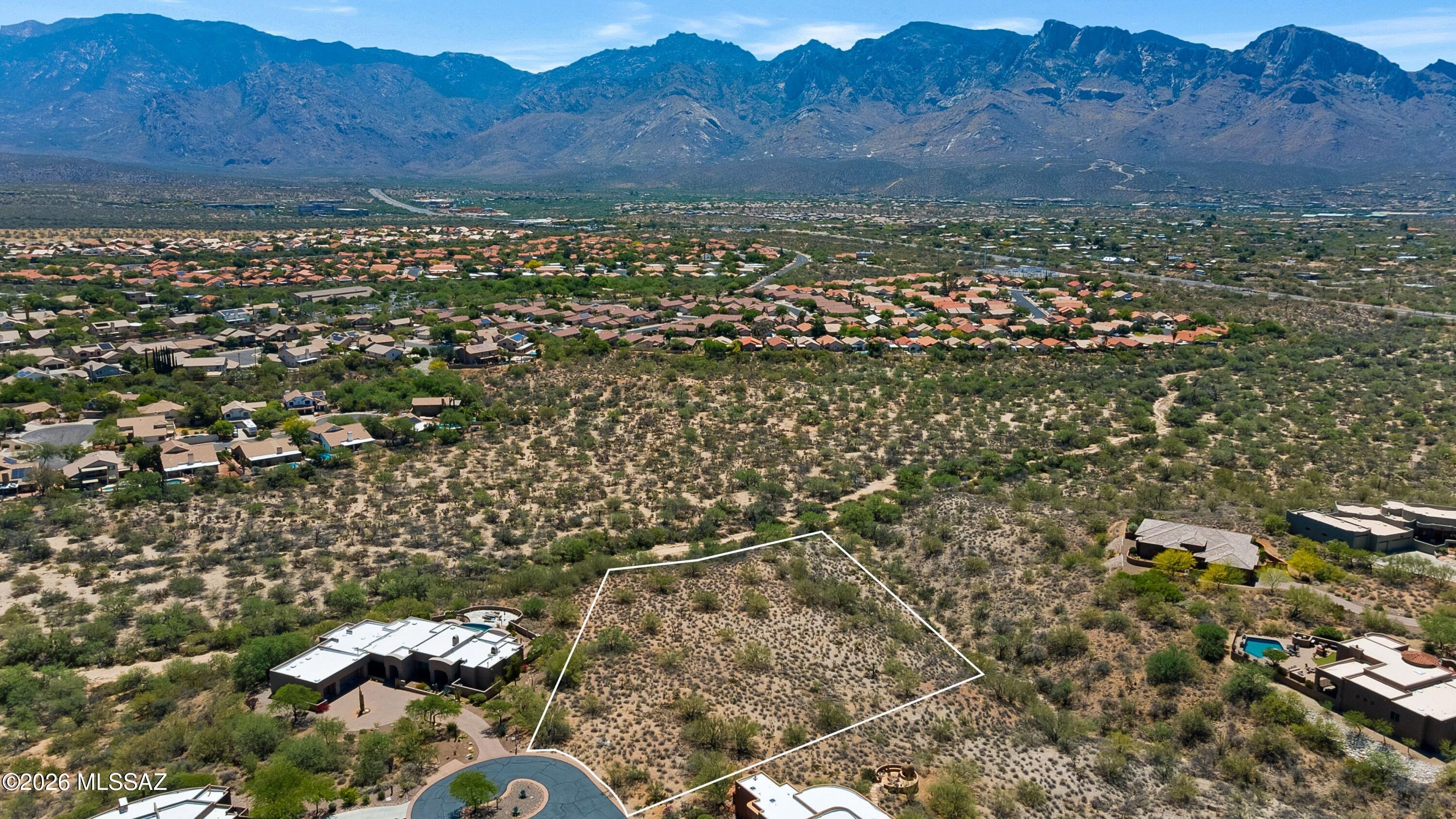 One of the few exceptional remaining custom lots in Oro Valley. This 1.86-acre custom homesite in Coyote Ridge has an elevated setting with stunning Catalina Mountain, Pusch Ridge, sunset, and city-light views. A generous building envelope offers ample room for a luxury custom residence, with guest accommodations, extra garage space, and/or resort-style outdoor living spaces. Surrounded by beautiful desert vegetation and upscale custom homes, this rare parcel combines privacy, natural beauty, and convenience just minutes from Oro Valley's shopping, dining, golf, and recreation opportunities. Build the custom home you've always envisioned on one of Oro Valley's premier lots.