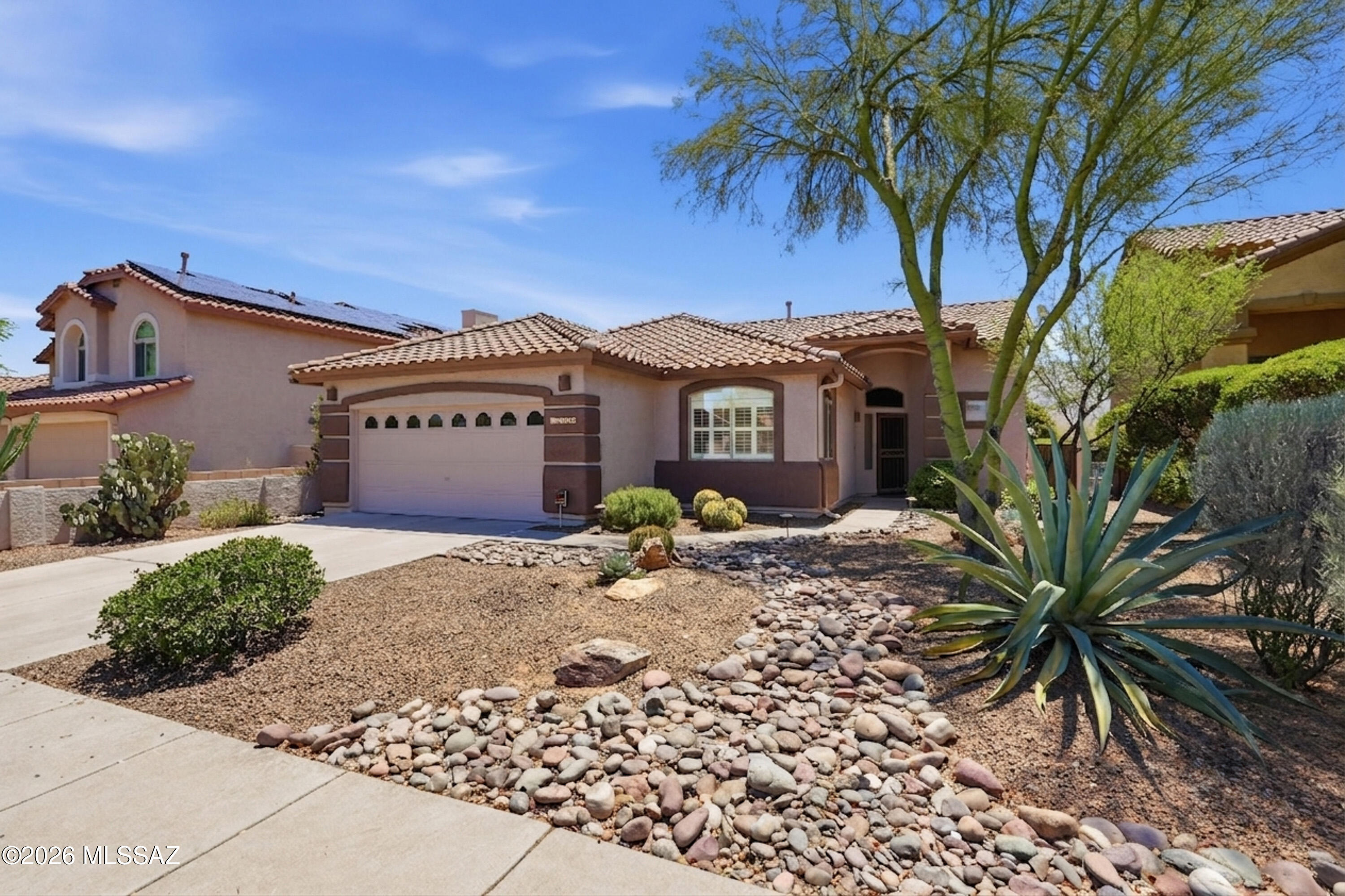Enjoy breathtaking mountain views from the extended east-facing flagstone patio in this beautifully maintained home. Featuring 10' ceilings and no carpet throughout, the home offers an updated kitchen with quartz countertops and stainless steel appliances, plus a cozy gas fireplace. Flexible floor plan with 2 bedrooms plus a den that can easily convert to a 3rd bedroom. Bathrooms have been stylishly updated with modern tile surrounds, fixtures, and lighting. Additional highlights include newer HVAC and a mini split in the garage--perfect for projects or hobbies. Unobstructed mountain views complete this exceptional property.  A rare opportunity to enjoy tasteful upgrades, functional living space, and stunning mountain views in one of Oro Valley's most sought-after settings.