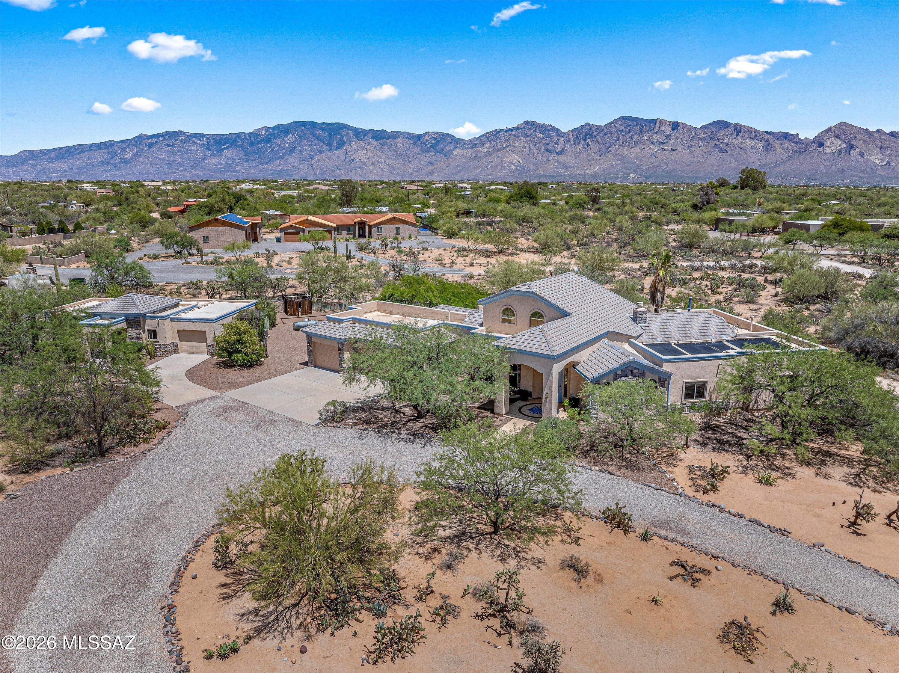 A rare opportunity to own a desert estate with sweeping Catalina Mountain views located just outside of Oro Valley, near La Cholla Air Park. This gated residence offers 3.3 pristine acres,  breathtaking views, and a proven track record as a successful short-term rental.  The main house is 3,372 sqft  has a split 4-bedroom + Loft floorplan with 3 full baths. The Great Room has vaulted ceilings & features a cooks kitchen with Thermador gas cooktop, electric oven & walk-in pantry.  The loft & viewing deck offer front-row views of three mountain ranges and the unforgettable Tucson sunsets.  The guest house is 812 sqft with 1 Bed/1 Bath, kitchen, living room, oversized garage with work bench & fenced yard. Over 1200 sqft of garage space for all your toys and a luxurious pool and spa! The guest house has two wide doorways into the bathroom and a roll-in shower. There is solar to heat the pool and a whole-house water descaler system.