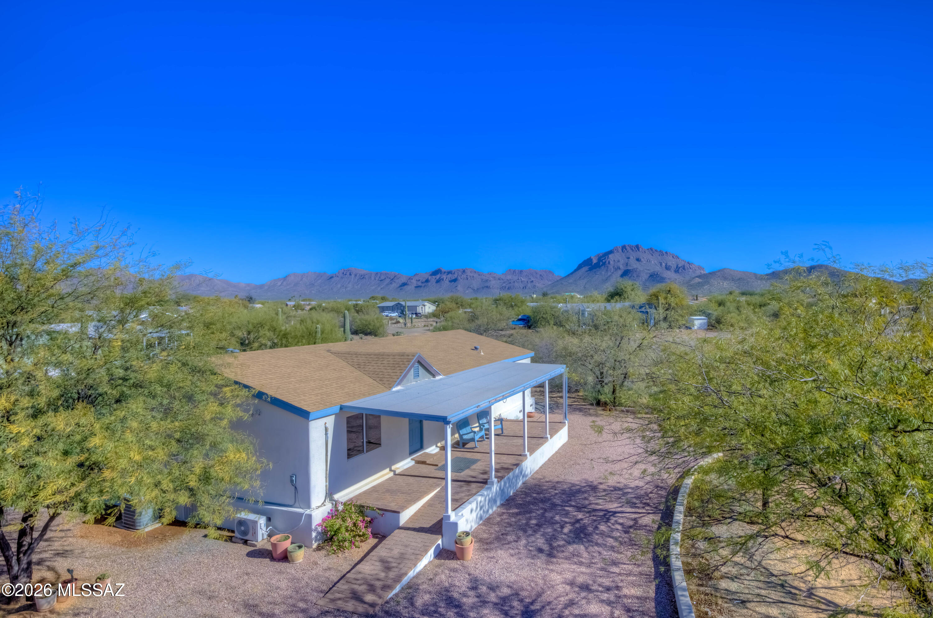 Discover PEACEFUL PRIVATE serenity on just over one acre in this beautifully maintained 3-bd, 2-ba home, ideally located on a corner lot off a paved road—no dirt road!. Enjoy relaxing on the covered front & back porches w/ pavers, perfect for outdoor living & a WOODFIRE PIZZA OVEN! Home is bright, open, & impeccably clean, offering plenty of space with both a living room & separate family room. Features include updated laminate flooring throughout (no carpet), newer kitchen cabinets, & a dedicated laundry room. Comfort ensured w/ central AC plus multiple energy-efficient mini-splits. Perfect for entertaining, this move-in-ready home also includes both the home and shed finished in stucco for a clean, cohesive look. Truly so much to offer—come SEE for yourself, you will not be disappoin