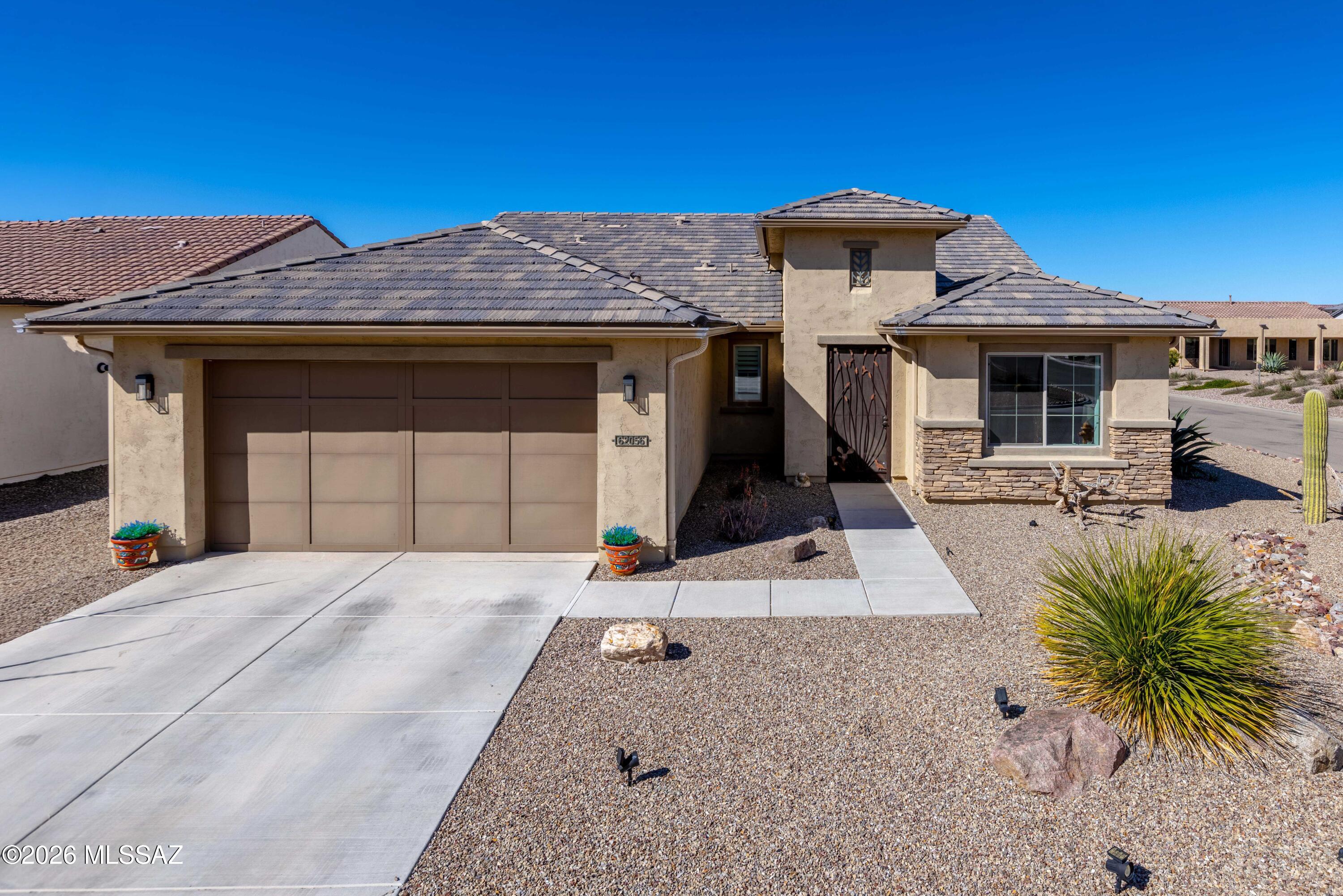 Step through the striking iron security screen door into this stunning Bella Model Home in the highly sought-after SaddleBrooke Ranch community. Thoughtfully designed for refined, low-maintenance living, this home features luxury vinyl plank, carpet, and tile flooring, plantation shutters, crown molding, and custom lighting throughout. The kitchen shines with under-cabinet lighting, while the extended master suite offers a private retreat complete with a makeup vanity. A guest bedroom captures beautiful front mountain views. The epoxy-floored garage includes hanging storage racks for effortless organization. Outside, enjoy a fully fenced, turf-landscaped yard with snake fencing and a concrete and paver patio -- perfect for Arizona living.