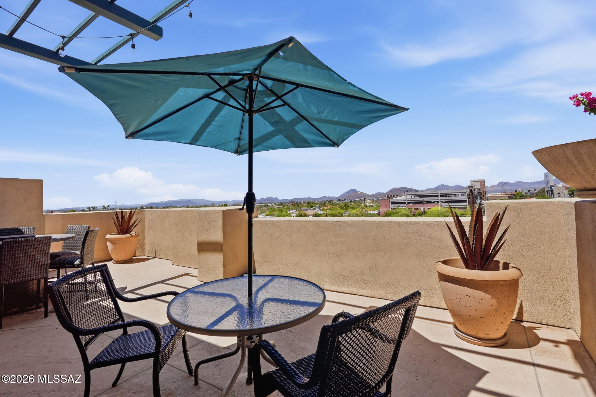 This condominium offers a blend of modern elegance and comfort. In the Sam Hughes neighborhood and close to U of A. The kitchen is equipped with granite countertops and stainless-steel appliances, complemented by a convenient breakfast bar for casual dining or entertaining.
The unit includes two primary suites. Both feature dual vanities with granite countertops and relaxing soaking tubs.
There is also a powder room for guests. The living areas showcase stylish tile flooring, while the bedrooms have  carpeted floors for added warmth. A laundry closet, with stackable washer and dryer, adds practical convenience. The HVAC system was replaced in 2022. A gas fireplace enhances the living space with warmth and ambiance, From the spacious patio, you can enjoy views of the 
U of A stadium, 'A' mountain, city lights and breathtaking sunsets, offering a  picturesque and vibrant setting. HOA covers water, gas, security, roof, and exterior and common area maintenance. Two reserved covered parking spaces are located south of the unit. Near Banner Hospital. Come and see all that Sam Hughes Place at the Corner has to offer.