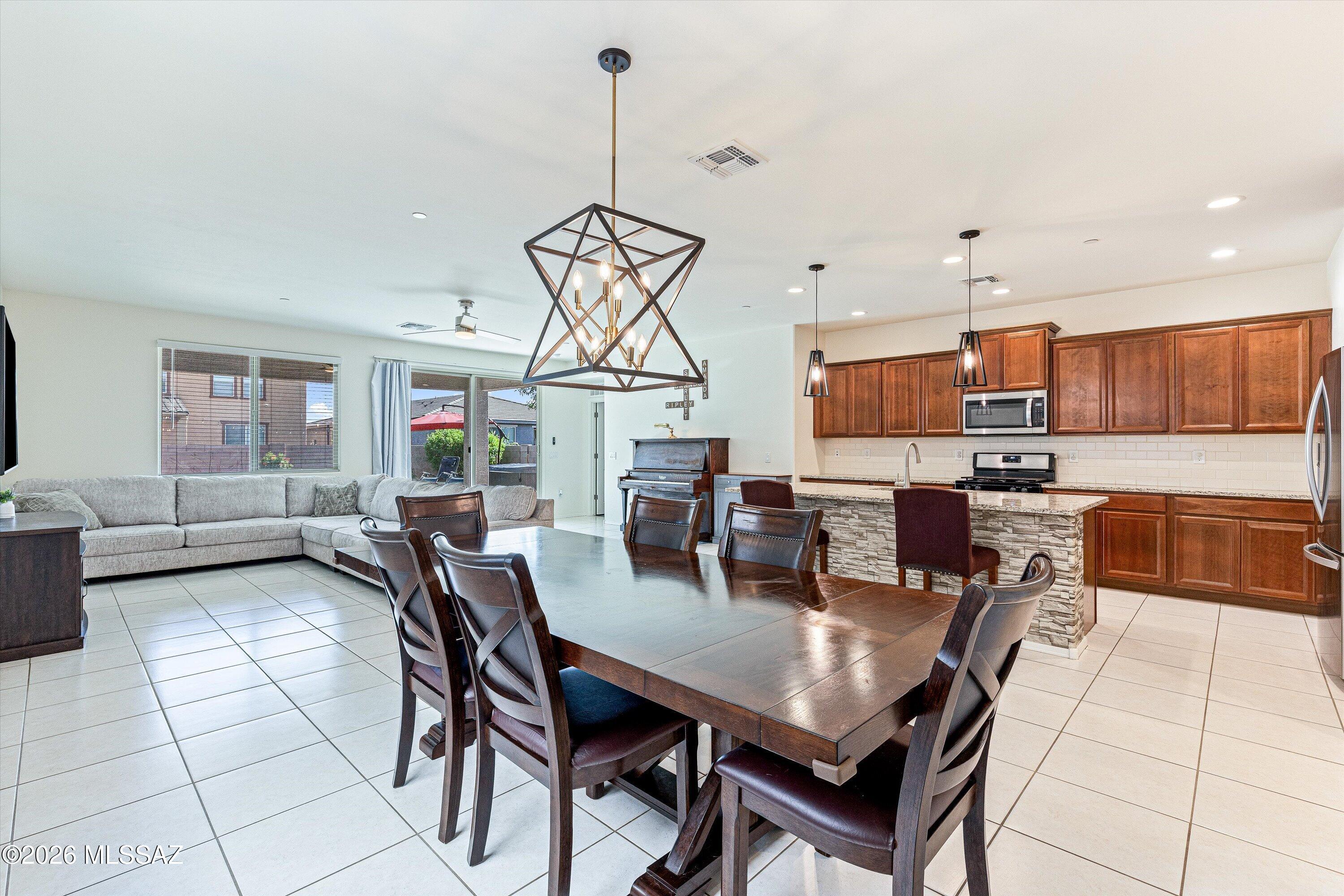 Filled with natural light, this beautifully designed two-story home features an expansive open-concept great room that seamlessly connects the kitchen, dining, & living areas--perfect for everyday living & entertaining. The oversized kitchen island serves as the heart of the home, offering plenty of space for family gatherings & casual dining. The versatile floor plan includes a spacious loft, a private first-floor ensuite ideal for guests or multigenerational living, & 3.5 baths. Step outside to a private backyard with an extended covered patio, pavers, & low-maintenance turf, creating the perfect space to relax or entertain. Built just six years ago & located in one of Marana's newer communities, near two elementary schools, neighborhood parks, wide biking paths, shopping, dining & more.