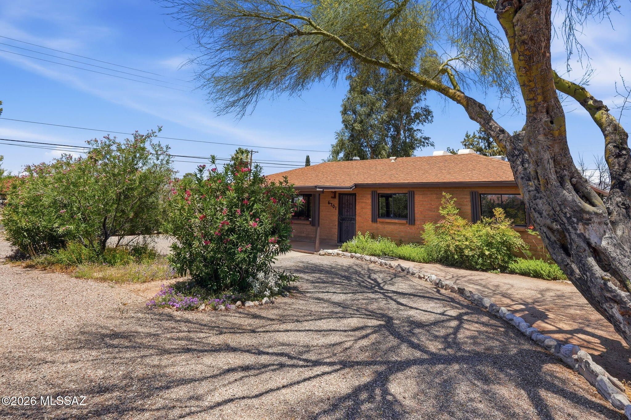 Meticulously maintained, brick home located on corner lot in desirable neighborhood on Tucson's east side.
Three-bedroom 2 bath, glowing with tons of light, additional extra-large great room and mid-century modern fireplace for cozy winter nights. Lush, well designed, low water use landscaping, with well-established trees all on irrigation front and back. Extra-large extended patio with aluminium facia. Hardscaping mixed with desert and greenery. Enjoy the outdoors and mountain views while using the custom-built brick BBQ and fireplace. Relax while viewing an expansive sunset from your beam mounted porch swing. Lots of built-in storage space outdoors and also, an attached indoor work room. Home designed with soft warm palette. New carpet, sturdy tile floors, ceiling fans, updated dual pan windows, security doors and windows throughout. Homeowner recently replaced HVAC, hot water heater, garbage disposal and backyard fence. Short, 2-block distance to elementary school and established neighborhood park. Park features include pool, splash pad, lighted sports fields, pickle ball, covered basketball, tennis courts and an off-leash dog park.
Don't miss an opportunity to be the first to view this impeccably maintained, one of a kind, solid property. This gem won't last!