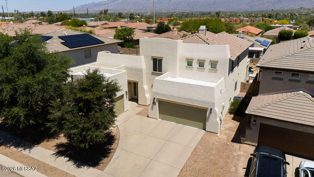 Beautifully maintained 5-bedroom, 3-bathroom home with pool offering an ideal blend of comfort, functionality, and resort-style outdoor living, this spacious residence also includes a dedicated office/den--perfect for working from home, a playroom, gym space, or multigenerational living. 
Step inside to soaring ceilings, abundant natural light, and an open-concept floor plan designed for both everyday living and entertaining. The inviting great room features dramatic architectural details, expansive windows, and a cozy fireplace that anchors the main living space, while the combination of travertine tile and rich wood flooring adds warmth and elegance throughout. The kitchen opens seamlessly to the living and dining areas and showcases granite countertops, abundant cabinetry, stainless steel appliances, breakfast bar seating, and updated modern lighting.
The spacious primary suite is a true retreat featuring a fully upgraded spa-inspired bathroom with an oversized walk-in shower, soaking tub, dual vanities, and an enormous walk-in closet. Generously sized secondary bedrooms, multiple living spaces upstairs and downstairs, updated fixtures and finishes, and dramatic vaulted ceilings throughout the home create the perfect combination of comfort and style for a growing family or those who love to entertain.
Step outside to your private backyard oasis complete with a sparkling pool, custom firepit lounge area, outdoor BBQ kitchen and covered patio--all framed by beautiful Catalina Mountain views and Arizona sunsets. The low-maintenance landscaping allows for easy year-round enjoyment, while the 3-car garage configuration featuring a 2-car garage and additional single-car garage offer plenty of space. 
Convenient East Tucson location near shopping, dining, parks, and top-rated schools make this home as practical as it is beautiful. This move-in ready home offers the perfect blend of space, functionality, and Arizona outdoor living. A rare opportunity you won't want to miss!
