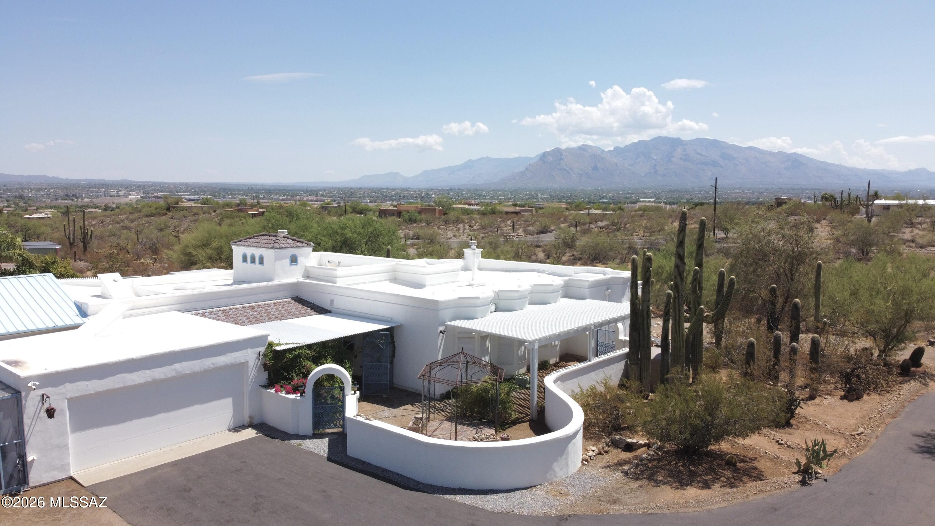 Custom built family home with bay windows, angular configurations, skylights , plenty storage throughout, built in bookcases in office. Perfect home for gathering/entertainment. Located in Tucson mountains on a hill top with panoramic views of sunrise/sunset, mountains and city. 3.03 acre lot with a large enclosed backyard to keep out desert critters, which includes an extended patio (length of the house),gated pool, plants and trees(lemon, grapefruit, pomegranate, fig). Enclosed area at front door with retractable awning and shade system covering. Large shop attached to west side of house, 3 pergolas with non-rust material(1 frontyard/2 backyard),2 rain catchers(NW and SE side of house), Percola water filter under kitchen sink and 2019 HVAC. Nearby trails for walking, biking & horses.