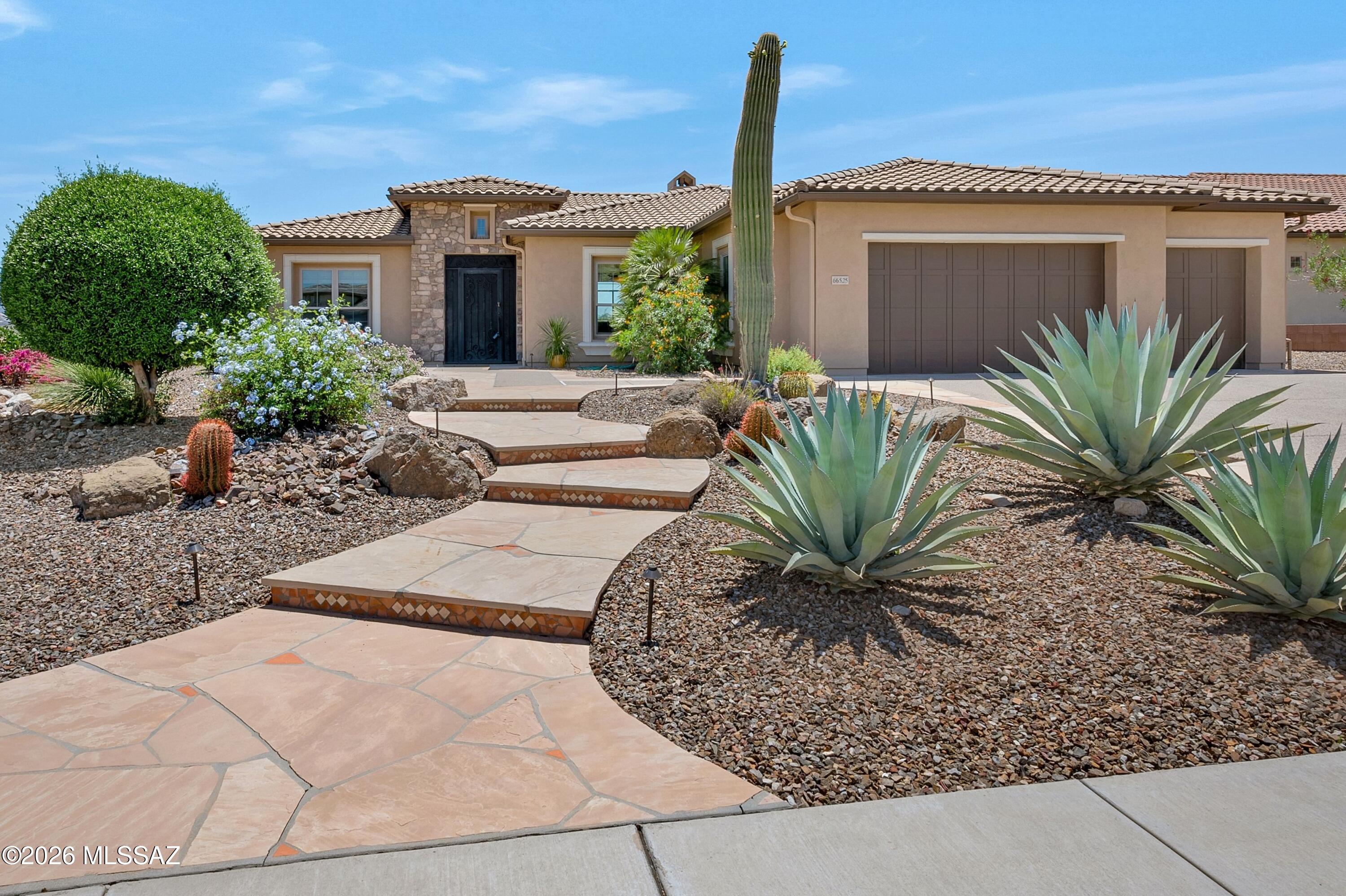 Panoramic vistas include the Catalina mountains and The Preserve Golf Course.
Set on an elevated corner lot above the 12th green. Elegant Sabino model showcases exceptional outdoor living space featuring a deep covered flagstone patio and additional patios of flagstone designed to capture the sweeping views.
This ideal desert home features a great room with 12-foot ceilings, a gas fireplace, and a wall of glass framing the beautiful views. The spacious kitchen includes a central island, granite countertops, and warm wood cabinetry, while the adjoining morning room provides a charming space for casual dining. Solid alder wood 8-foot interior doors are found throughout, and wood flooring extends through the great room, primary bedroom, and den, with tile in the entry, kitchen, and baths. The split-bedroom layout offers privacy, and both bedroom suites have exterior doors that open to the covered patio. Window treatments include plantation shutters, woven shades, and automated screens in the great room.
3 car garage with exterior door to the side yard.
South exposure from the back of the house and patio.