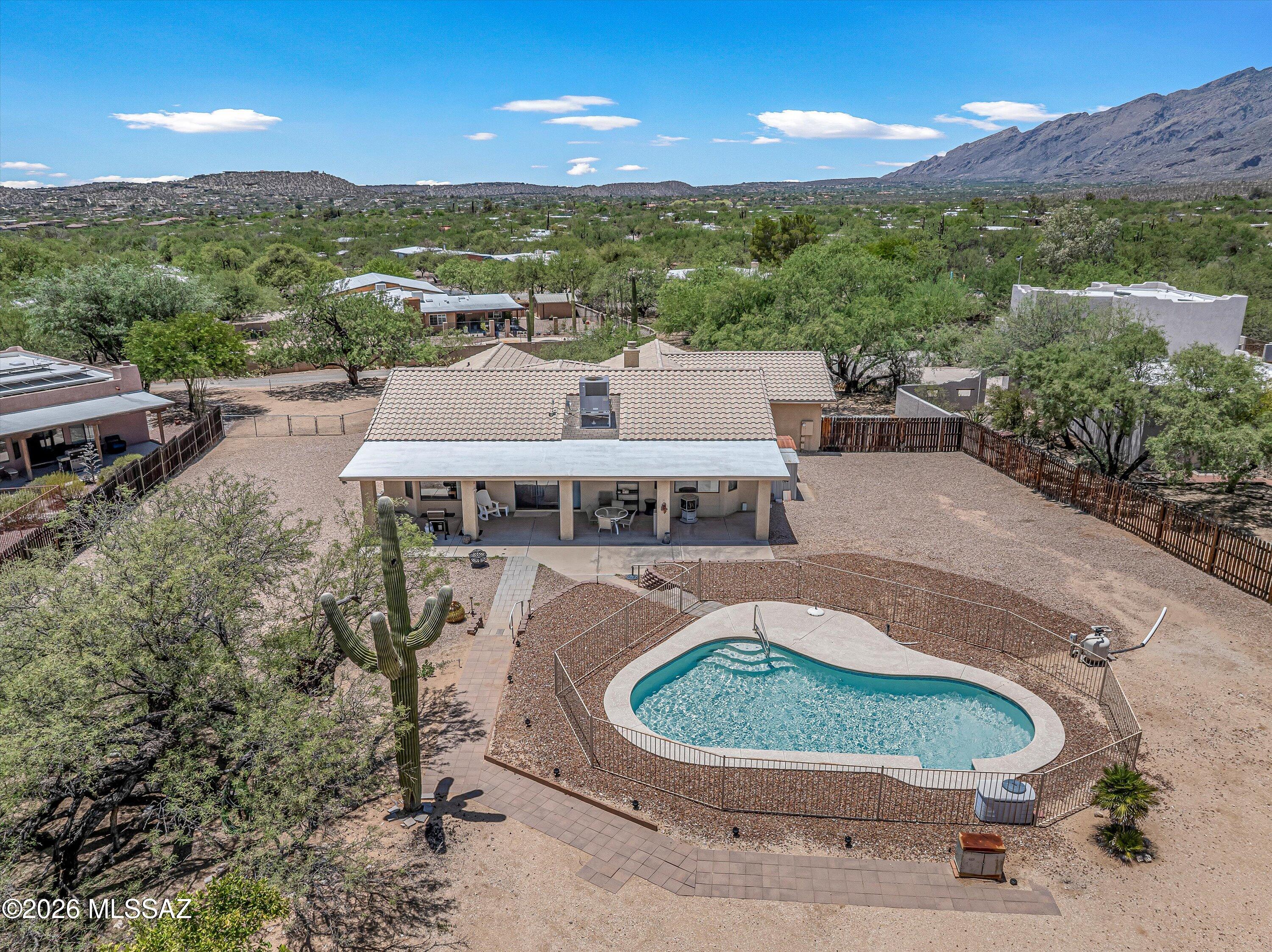 Nestled on a sprawling .83-acre lot with the stunning Catalina Mountains as your backdrop, this meticulously maintained  3-bedroom, 2-bath home  features high ceilings, a spacious great room, and a split bedroom floor plan that provides both an open, inviting living space and added privacy for the primary suite. The oversized 3-car garage provides additional flexibility for storage, larger vehicles, or a dedicated workspace. Step outside to an expansive backyard with a beautiful fenced pool, RV gate and hookups, and plenty of room to create the outdoor retreat you've been dreaming of. Whether you have recreational vehicles, outdoor toys, or future plans to expand, this property offers exceptional versatility. Ideally located just minutes from hiking and biking trails, parks, shopping, dining, and schools, you'll enjoy the best of Northeast Tucson living! Plus, you're just a short drive from Mount Lemmon, Tucson's favorite mountain retreat, where cooler temperatures, scenic forests, hiking, skiing, and charming Summerhaven offer a refreshing escape from the desert heat year-round. Tucked away near the end of a charming, short dirt lane, lined with mature trees and shared by only a few neighboring properties, this home offers both peaceful surroundings and endless potential, and a wonderful opportunity to make this home your own - all with no HOA. Recent improvements include a newer HVAC system and water heater, both replaced within the last 5 years. Price range listing : Seller will accept or counter offers between $600,000 - $625,000.