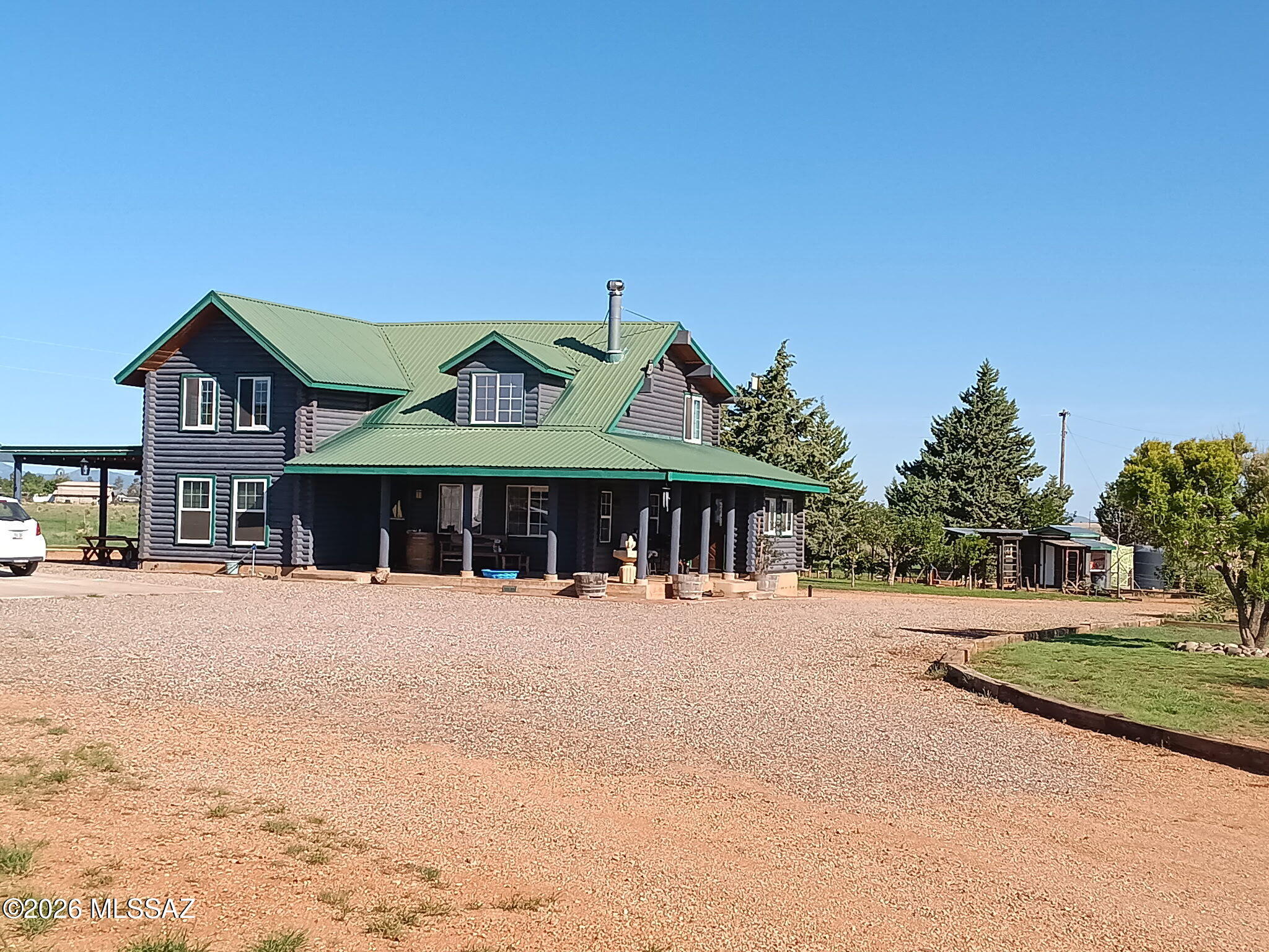 Beautiful Log Home in Elgin, gated & fully fenced, park like 10 acres with large mature trees, Hot tub & Swim spa, fenced garden, fruit trees, small vineyard, chicken coop, goat pen, mare motel & 2 large pastures. A Detached garage with owned solar panels, 2 carports & large dog kennel. Private Well with water storage tank. Home has real wood floors, wood burning stove in living room, granite counter tops in kitchen, gas range, farmhouse sink, stainless steel appliances, laundry room, large bedroom and bathroom downstairs, & a huge bedroom w/walk-in closet, bathroom w/dual sinks, shower & a large loft upstairs, room for 3rd bedroom! You can ride your horses to the local wineries, and an easy commute to Tucson, Neighbor has 5 acres next door can possibly be purchased