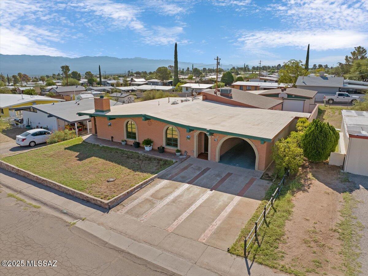Step into timeless character and craftsmanship with this one-of-a-kind, 3 bedroom 1 bath, 1962 slump block bungalow in historic San Manuel. Lovingly cared for by only 2 owners, this 1,825 sq. ft. home showcases true vintage charm with vaulted ceilings, exposed wood beams, and a stunning brick fireplace that anchors the spacious living room. From the moment you step inside, you'll feel home. The custom brick and stone tile finishes, built-in bookshelves in entry & dining areas, and beautiful French wood doors that bring in soft natural light create a timeless cozy rustic atmosphere. The kitchen is adorned with a custom-built brick breakfast bar (unique iron Arizonian stools included), Being sold  AS IS'' Knotty pine handmade cabinet fronts & built-ins that add warmth and personality you won't find in newer homes. While modern touches like the Kenmore Elite refrigerator & GE convection oven give you peace of mind.
The spacious primary bedroom is truly a retreat! Measuring 20' x 15', with vaulted wood-planked ceilings, an impressively large 17-foot mirrored walk-in closet, and private outdoor access. Every detail speaks to quality and durability, from the masonry construction to the thoughtful built-ins that maximize both beauty and function. A second bedroom and cozy 13' x 10' Arizona room provide extra space, opportunity, and flexibility to have for an office, sunroom, gameroom, or studio. 
The bathroom is generously sized and beautifully tiled from floor to ceiling! Soak away the worries of the day in the spa tub, with tiled step decking, surrounded by your favorite candles, salts, and plants. OR step into your tiled walk-in shower with the option to control water usage with a water-saving toilet and classic pedestal sink past and present blend seamlessly even here.
Outdoors, the back and side yards are enclosed by a masonry wall and 2 sets of double gates giving you true privacy, access, and peace of mind. Car enthusiasts, those who love to tinker or those needing serious workshop space, will truly appreciate the detached 2-car garage. It measures 16' x 30' & includes hookups for an air compressor, arc welder, and more. Entertainers will enjoy the shaded carport area that extends from the garage, the brick garden boxes ready for flowers or vegetables, mountain views and the built-in masonry BBQ. 
This home offers the perfect blend of privacy, comfort, character, community and utility. Conveniently located the community center, playground, public school, library, and local shops are all within walking distance and Highway 77 offers an easy 30-40 minute commute into Catalina and Oro Valley. This gem is worth seeing in person!