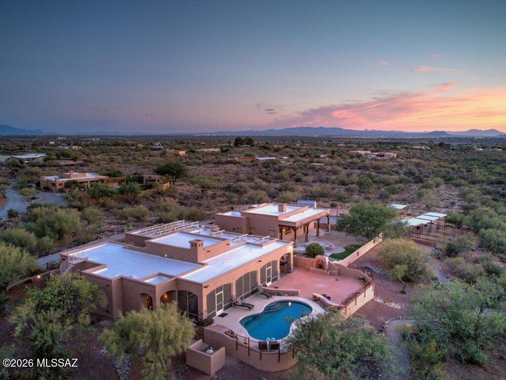 One-of-a-kind horse property with breathtaking mountain views! Nestled on 3.73 acres, this stunning estate offers 3,410 sq. ft. of living space, including a 2,307 sq. ft. main home and a 1,103 sq. ft. detached guest house. Originally crafted by renowned builder Buddy Greer, the property combines timeless Southwestern architecture with modern upgrades and exceptional outdoor amenities.

The main residence welcomes you through a gated courtyard into an open-concept floor plan featuring rustic hand-carved wood beams, a stacked stone fireplace, granite countertops, stainless steel appliances, and a full-length Arizona room ideal for year-round entertaining. Additional upgrades include a Tesla EV charger and a water softener system serving the main home. The spacious three-car garage provides ample storage, while the owned solar system helps enhance energy efficiency.

Equestrian enthusiasts will appreciate the newly added horse stalls and arena, creating a true horse-lover's paradise. Recent improvements include freshly painted exteriors on the main home, guest house, and fencing, as well as a roof recoat completed approximately one year ago.

The detached guest house offers exceptional privacy and comfort with a spacious bedroom, luxurious soaking tub, stacked stone fireplace, spectacular mountain views, and a recently installed heat pump HVAC system for year-round comfort.

Outside, enjoy beautifully landscaped grounds, multiple outdoor living spaces, a sparkling pool, and endless opportunities to relax while taking in Tucson's stunning desert sunsets. A rare opportunity to own a private desert oasis offering the perfect blend of luxury, functionality, and wide-open space.