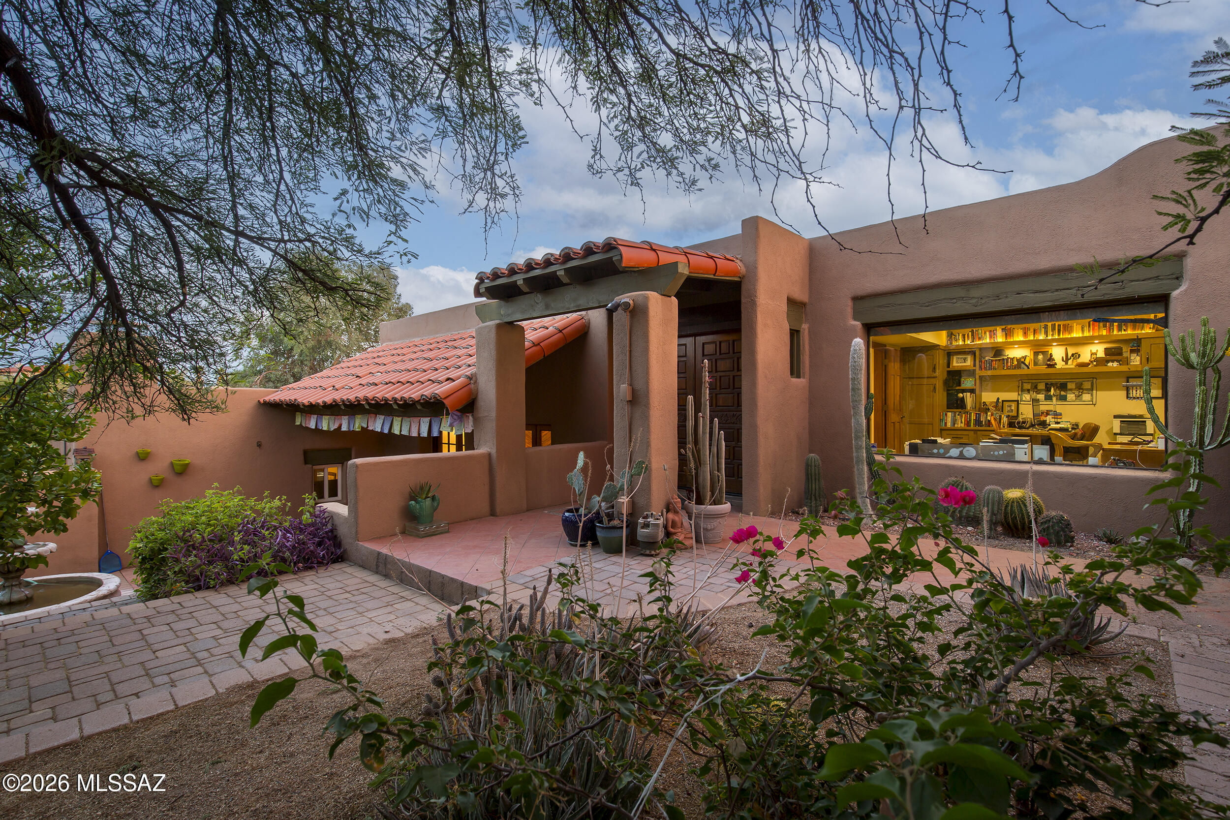 Beautiful Santa Fe home in Catalina Foothills.  Set amongst natural desert w/amazing mountain and city views, this home offers peace and tranquility on nearly an acre.  3Br, 2ba w/office has great natural sunlight throughout and is great for entertaining w/four separate patios.  Engineered wood flooring on mid & lower levels w/a thick adobe wall (entry).  Exposed wood beams in living rm/beautiful beehive fireplace overlooks a stunning patio space.  A short distance to great restaurants, hiking, Whole Foods and outdoor activities.